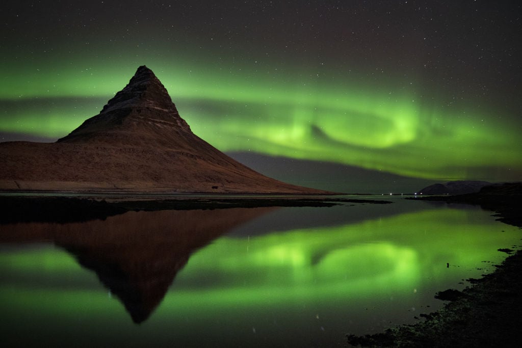 La aurora boreal sobre la montaña Kirkjufell, que se encuentra en la costa norte de la península de Snaefellsnes en Islandia, cerca de la ciudad de Grundarfjordur. Fecha de la foto: viernes 8 de diciembre de 2023. (Foto de Owen Humphreys/PA Images a través de Getty Images)