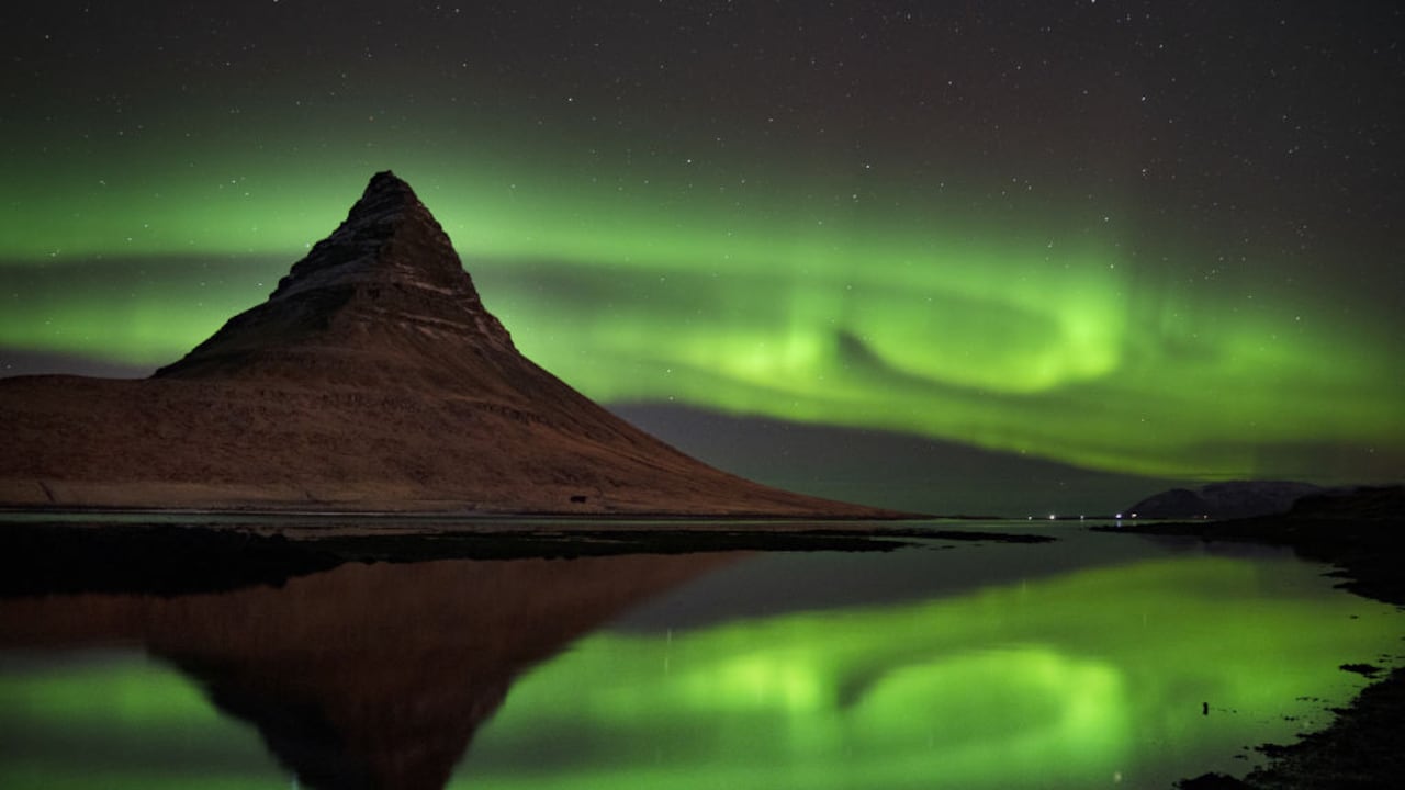 La aurora boreal sobre la montaña Kirkjufell, que se encuentra en la costa norte de la península de Snaefellsnes en Islandia, cerca de la ciudad de Grundarfjordur. Fecha de la foto: viernes 8 de diciembre de 2023. (Foto de Owen Humphreys/PA Images a través de Getty Images)