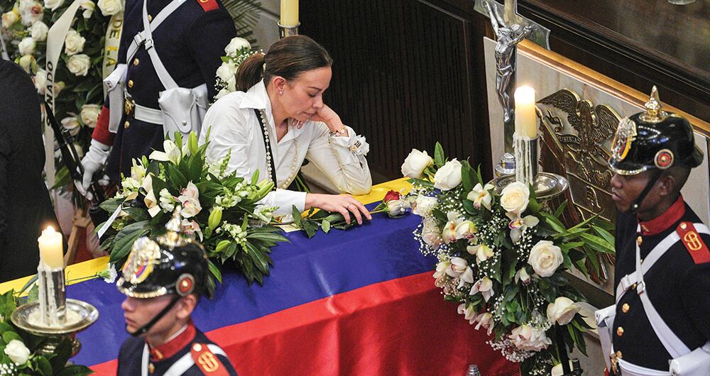 María Claudia Tarazona junto al ataúd de su esposo Miguel Uribe Turbay. 