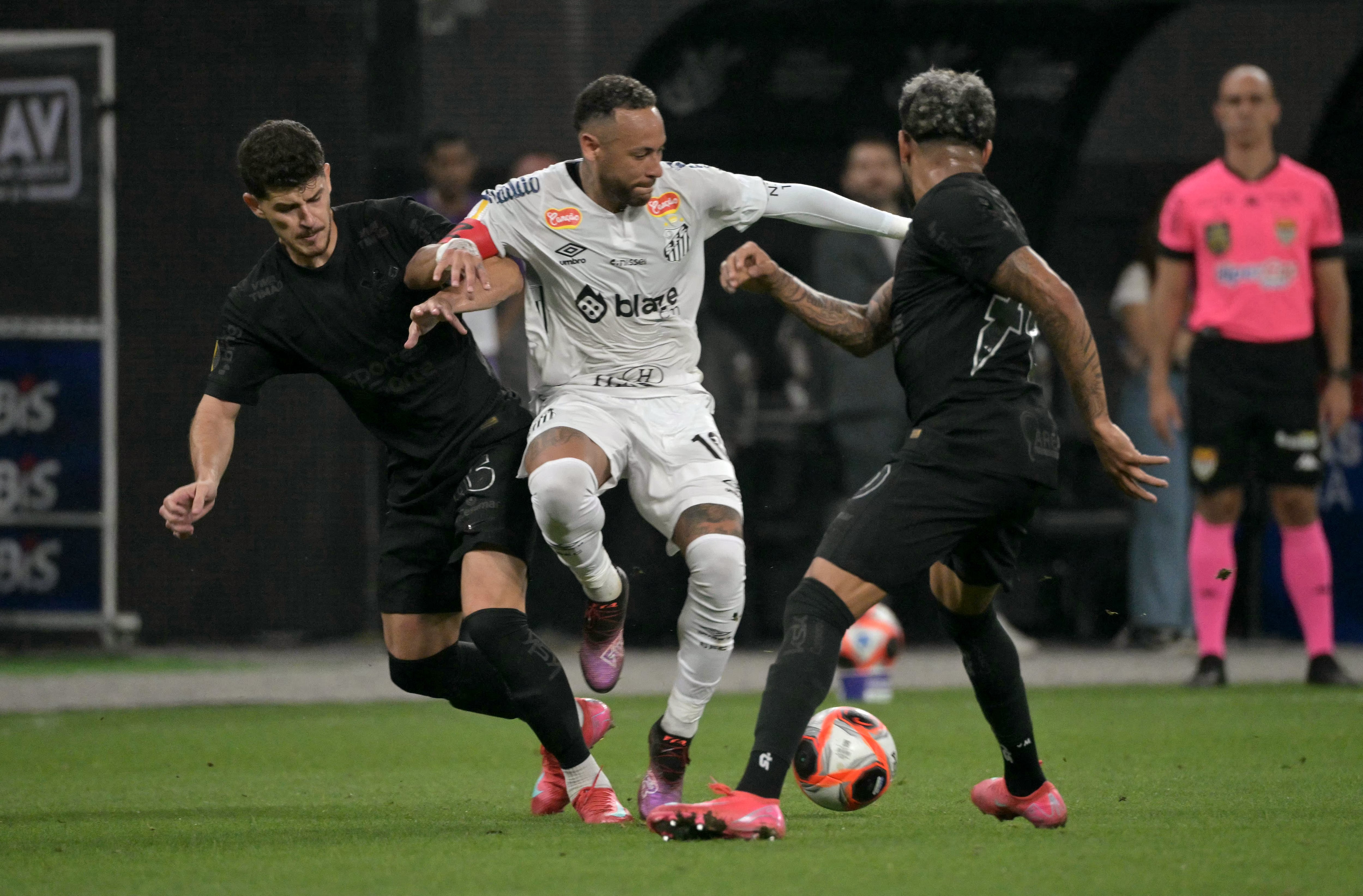 El delantero del Santos #10 Neymar (C), el defensa del Corinthians #05 Andre Ramalho Silva (L) y el centrocampista venezolano #70 José Martínez luchan por el balón durante el partido de fútbol del Campeonato Paulista A1 entre el Corinthians y el Santos en el Arena Corinthians de Sao Paulo el 12 de febrero de 2025.