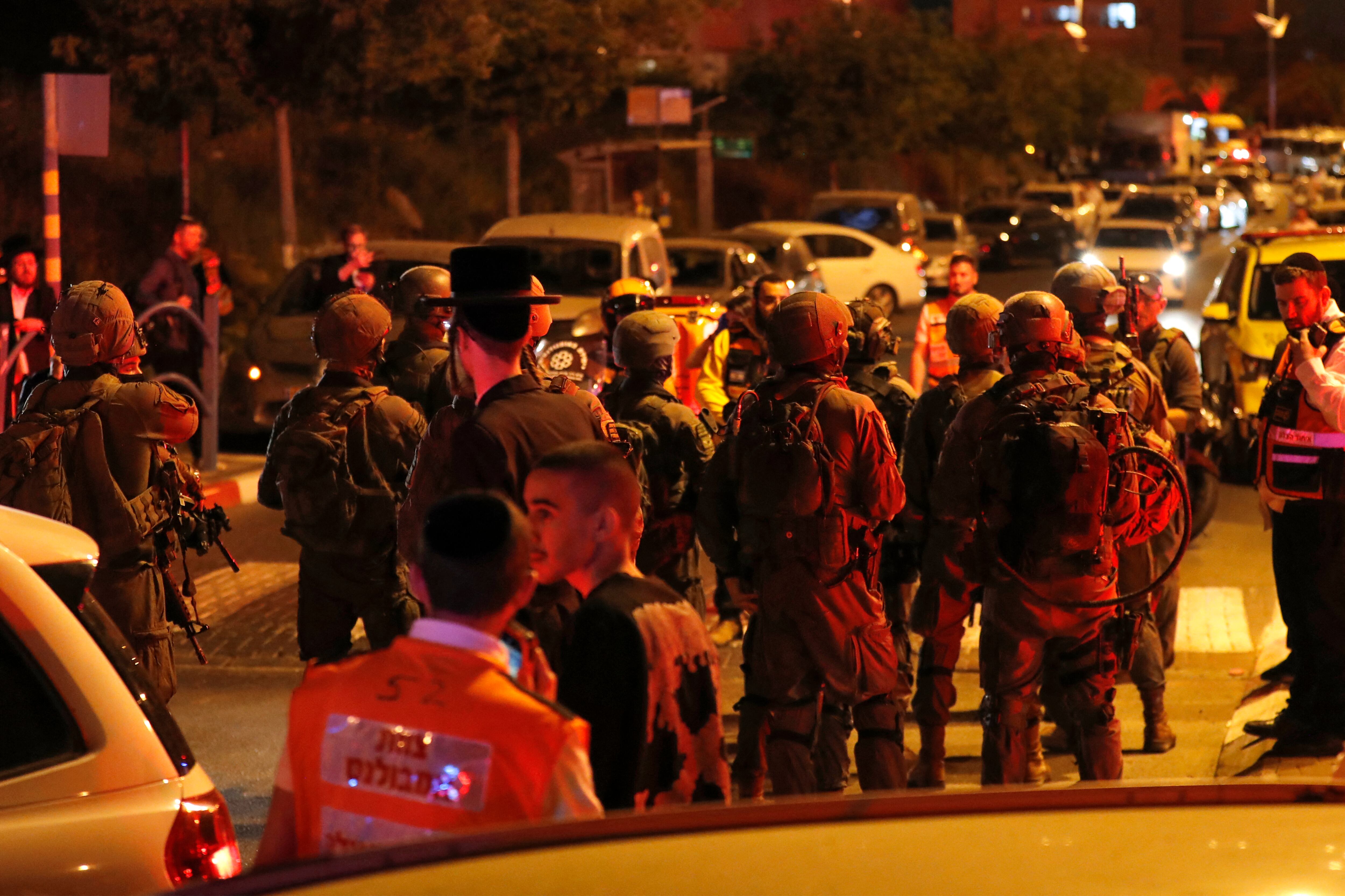 La policía y los médicos israelíes se muestran en la escena de un ataque en la ciudad central de Elad, el 5 de mayo de 2022. - Al menos tres personas murieron en un ataque en la ciudad central israelí de Elad cuando el estado judío celebró su día de la independencia. hoy, dijeron los médicos (Foto de Ahmad GHARABLI / AFP)