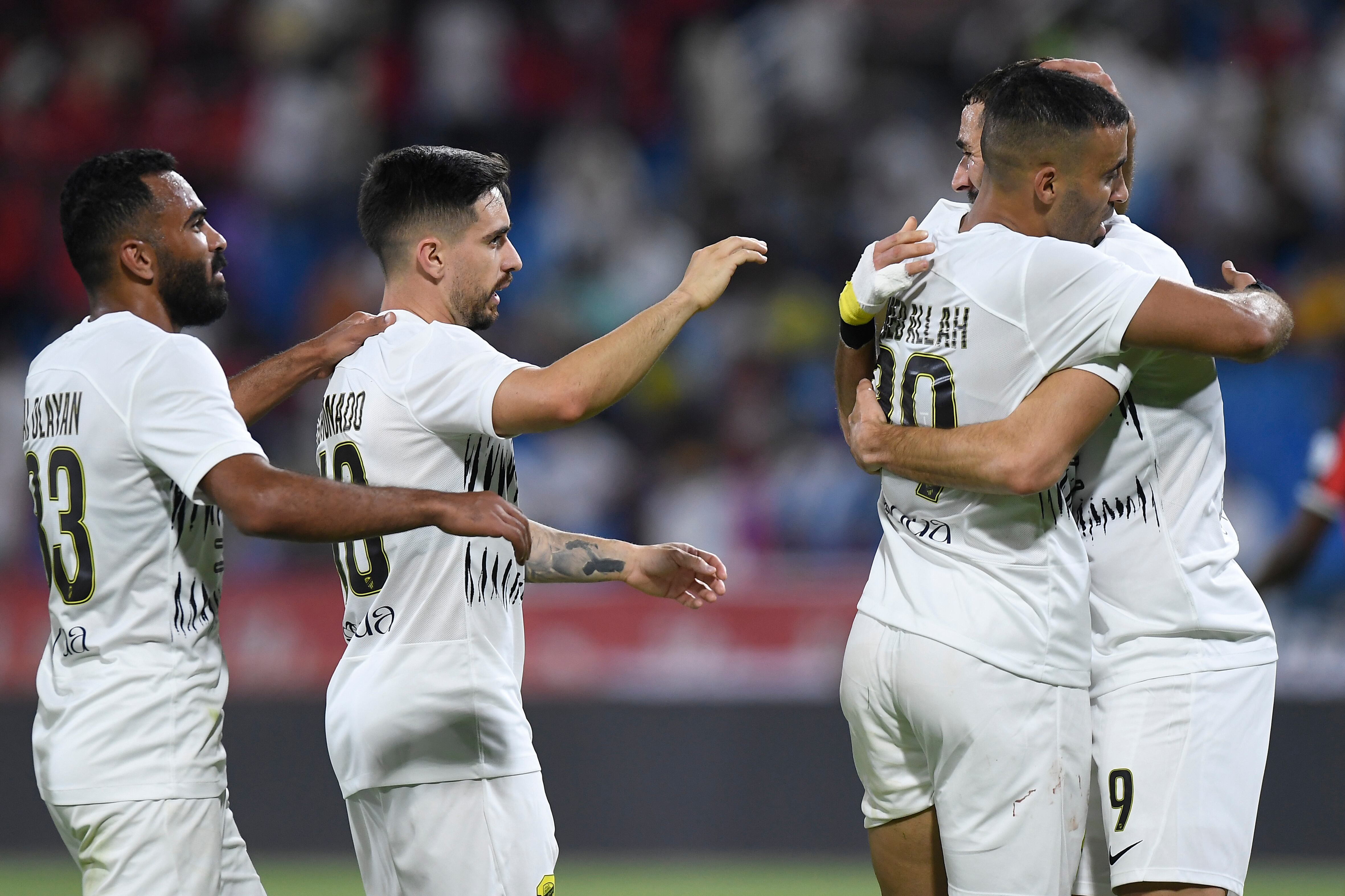 Al Ittihad's Karim Benzema, right, is greeted by his teammates during his team match against Al Raed in Saudi Professional League, in Buraidah, Saudi Arabia, Monday, Aug. 14, 2023. (AP Photo)