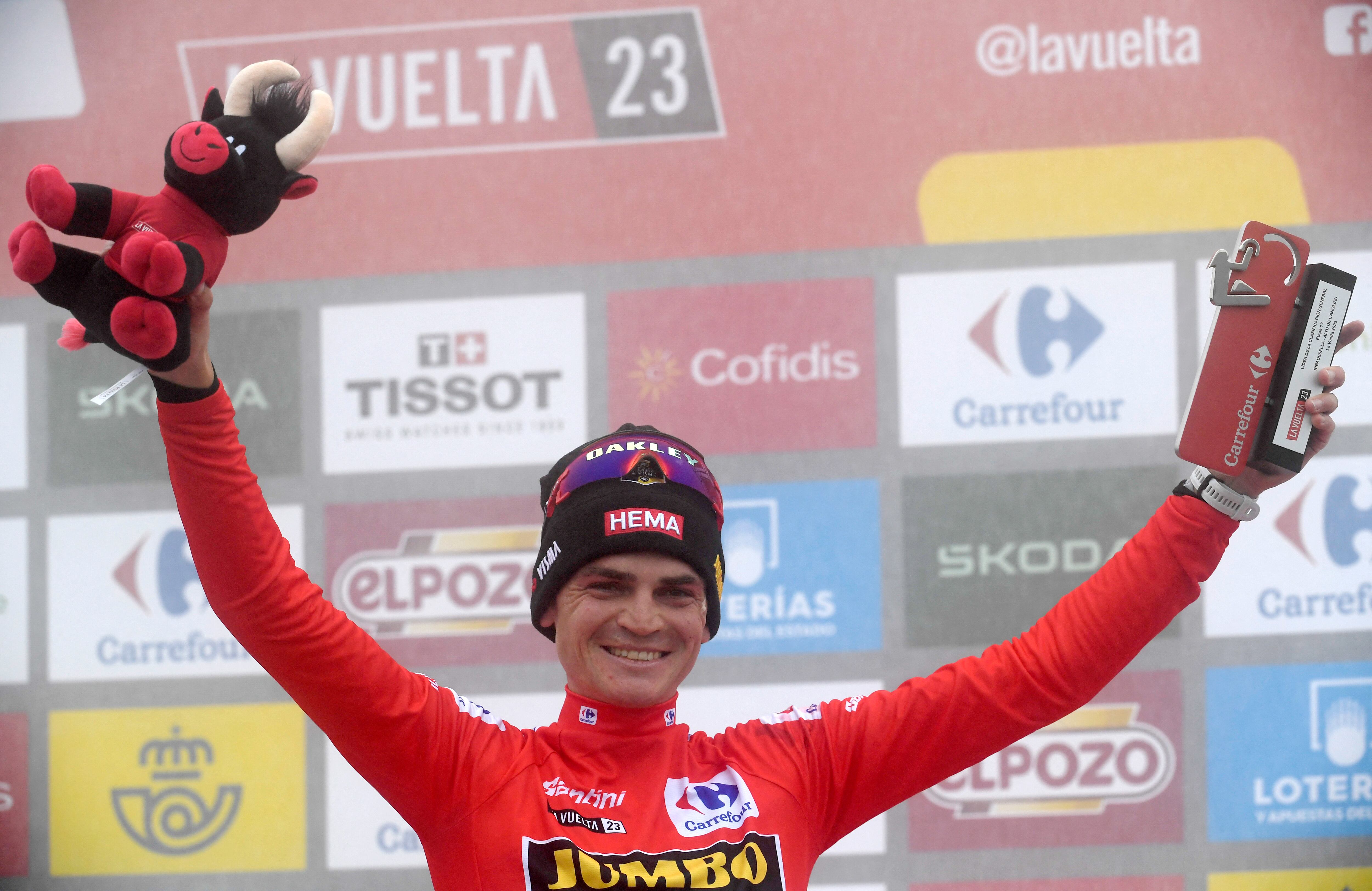 Team Jumbo-Visma's US rider Sepp Kuss celebrates on the podium reataining the overall leader's red jersy after the stage 17 of the 2023 La Vuelta cycling tour of Spain, a 124,4 km race between Ribadesella and Alto de l'Angliru on September 13, 2023. (Photo by MIGUEL RIOPA / AFP)