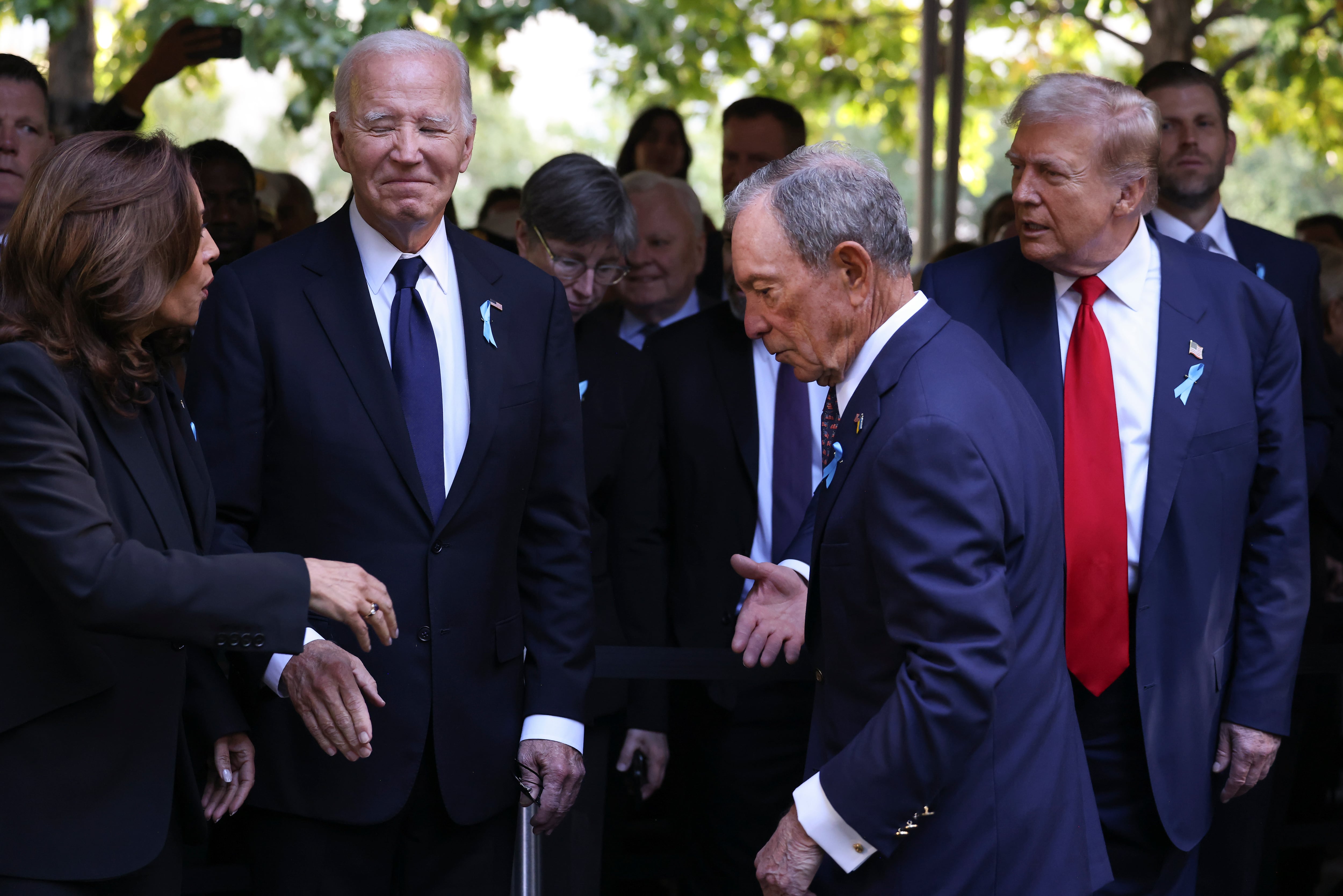 La vicepresidenta candidata demócrata a la presidencia, Kamala Harris (extrema izquierda), saluda al candidato presidencial republicano, el expresidente Donald Trump (extrema derecha), mientras el presidente Joe Biden y Michael Bloomberg observan su llegada a la ceremonia conmemorativa del 11 de septiembre en el 23º aniversario del 11 de septiembre. , Ataques terroristas de 2001, miércoles 11 de septiembre de 2024, en Nueva York.