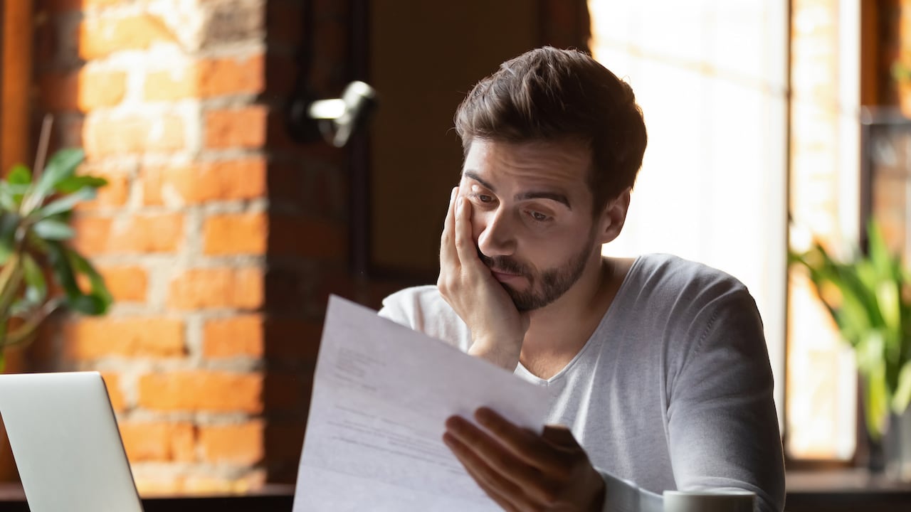 Confused frustrated young man reading letter in cafe, debt notification, bad financial report, money problem, money problem, upset student receiving bad news, unsuccessful exam or test results