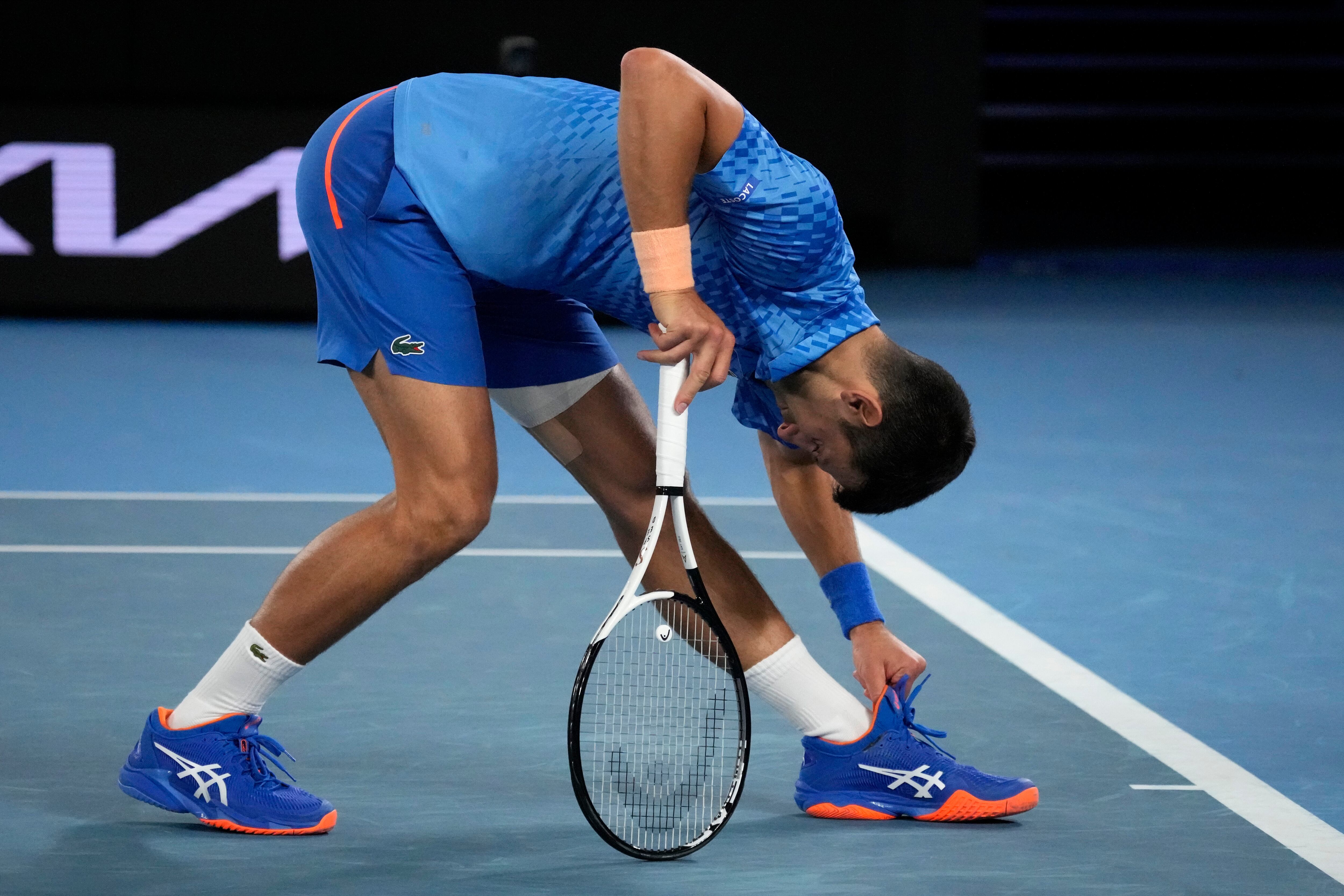 Novak Djokovic of Serbia stretches during their third round match against Grigor Dimitrov of Bulgaria at the Australian Open tennis championship in Melbourne, Australia, Saturday, Jan. 21, 2023. (AP Photo/Aaron Favila)