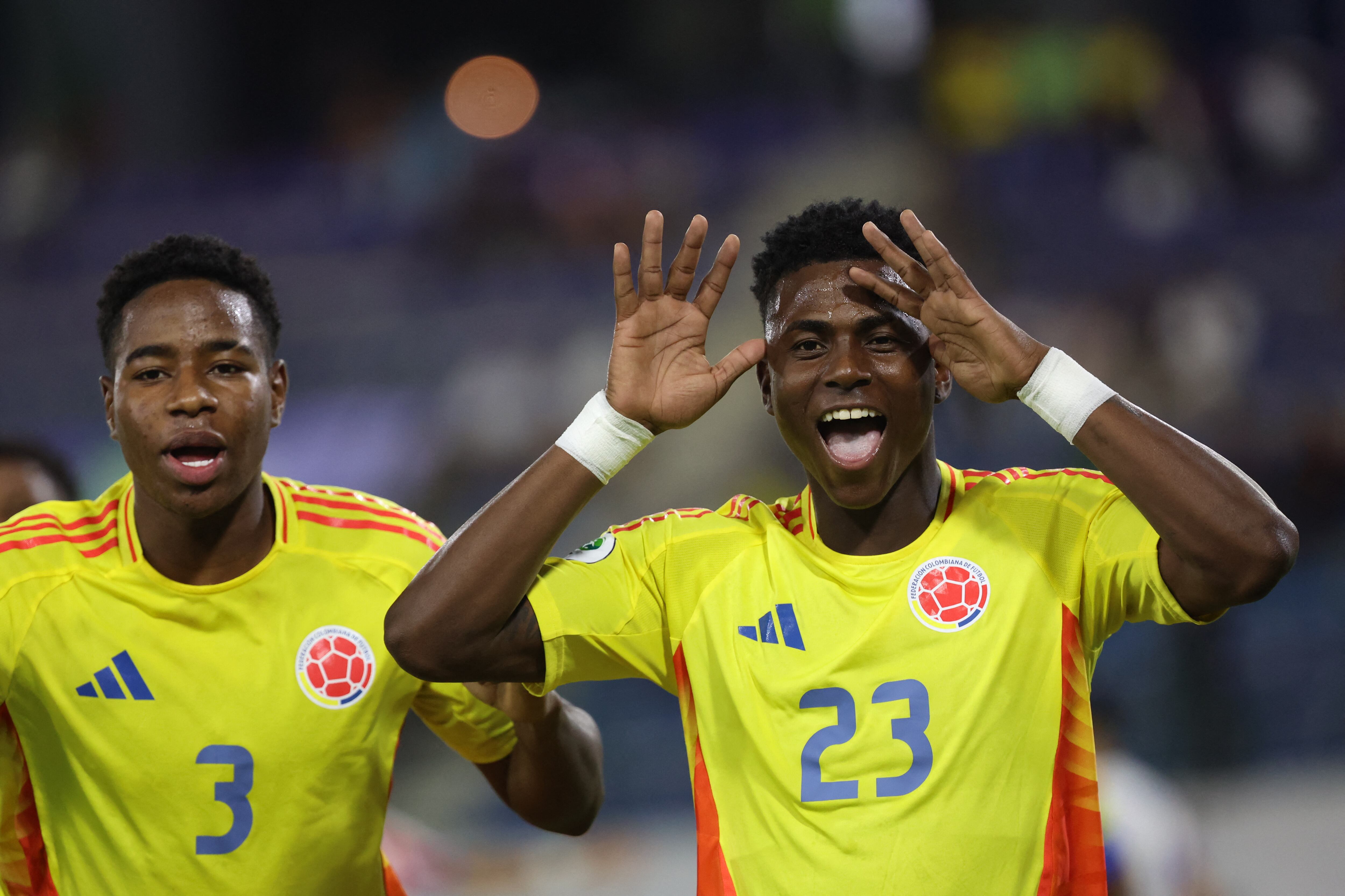 Colombia's midfielder #23 Neiser Villarreal celebrates with teammate Colombia's defender #03 Keimer Sandoval after scoring a goal during the 2025 South American U-20 football championship final round match between Colombia and Paraguay at the Br�gido Iriarte stadium in Caracas on February 4, 2025. (Photo by Edixon GAMEZ / AFP)