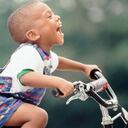 Niño feliz montando en bicicleta