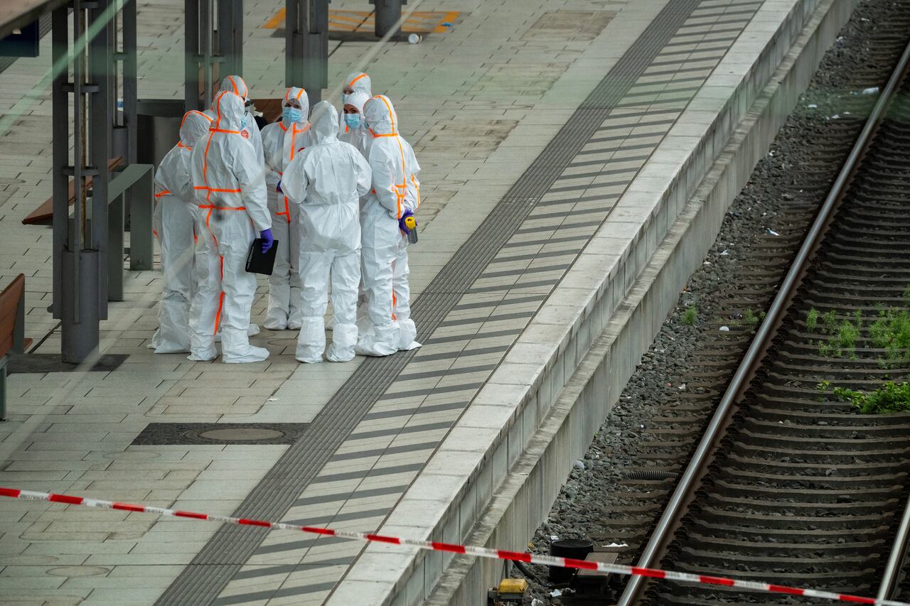 Forensic police officers investigate on the railway platform at Hamburg's main train station where at least 12 people have been injured in a knife attack on May 23, 2025. A knife attack at the main station in the German city of Hamburg left at least 12 people injured with some of them in a life-threatening condition, local emergency services said. (Photo by Jonas Walzberg / AFP)