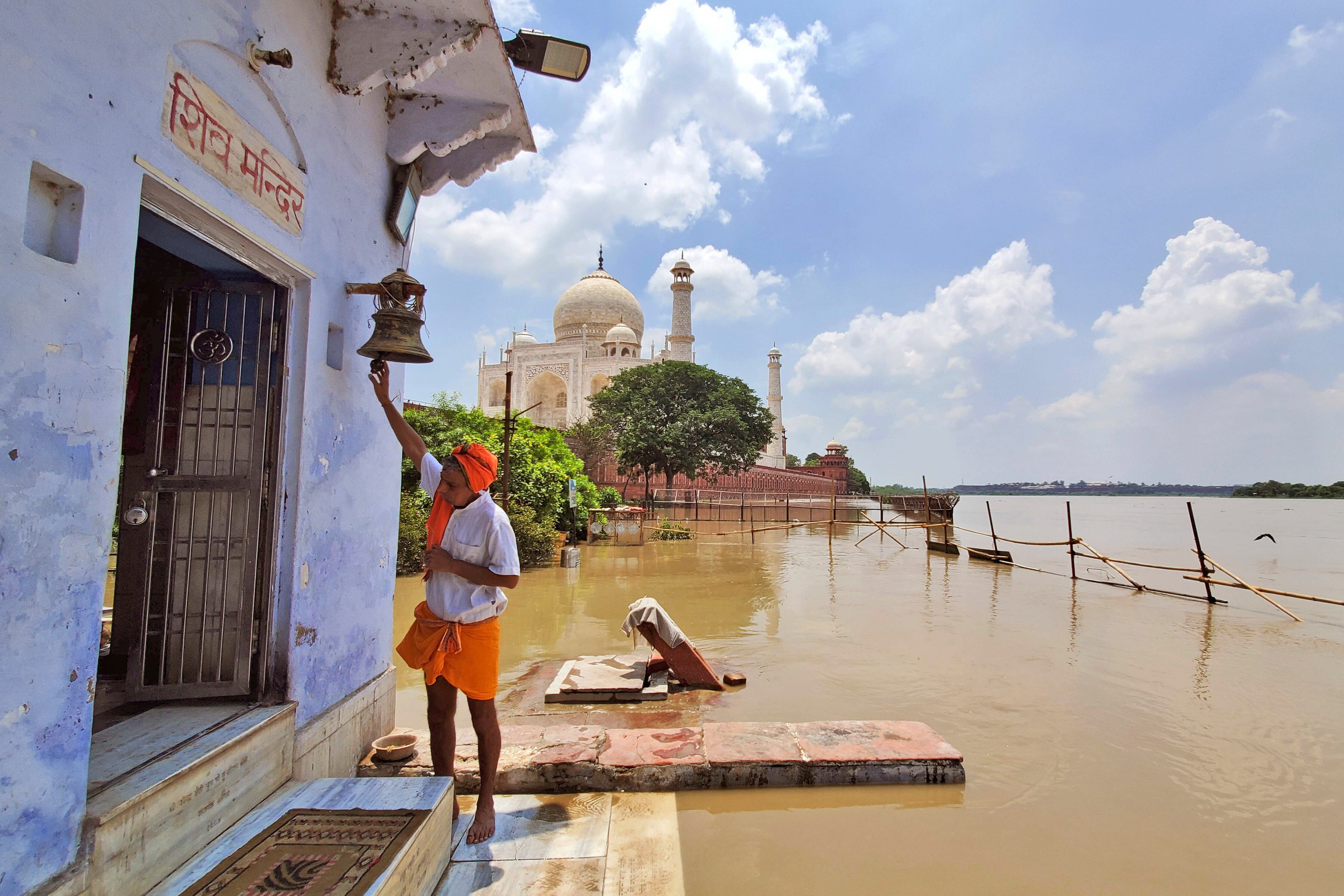 Un hombre adora en un templo del dios hindú Shiva de pie junto a un río Yamuna crecido que fluye hasta la periferia del monumento Taj Mahal en Agra, India, el miércoles 19 de julio de 2023
