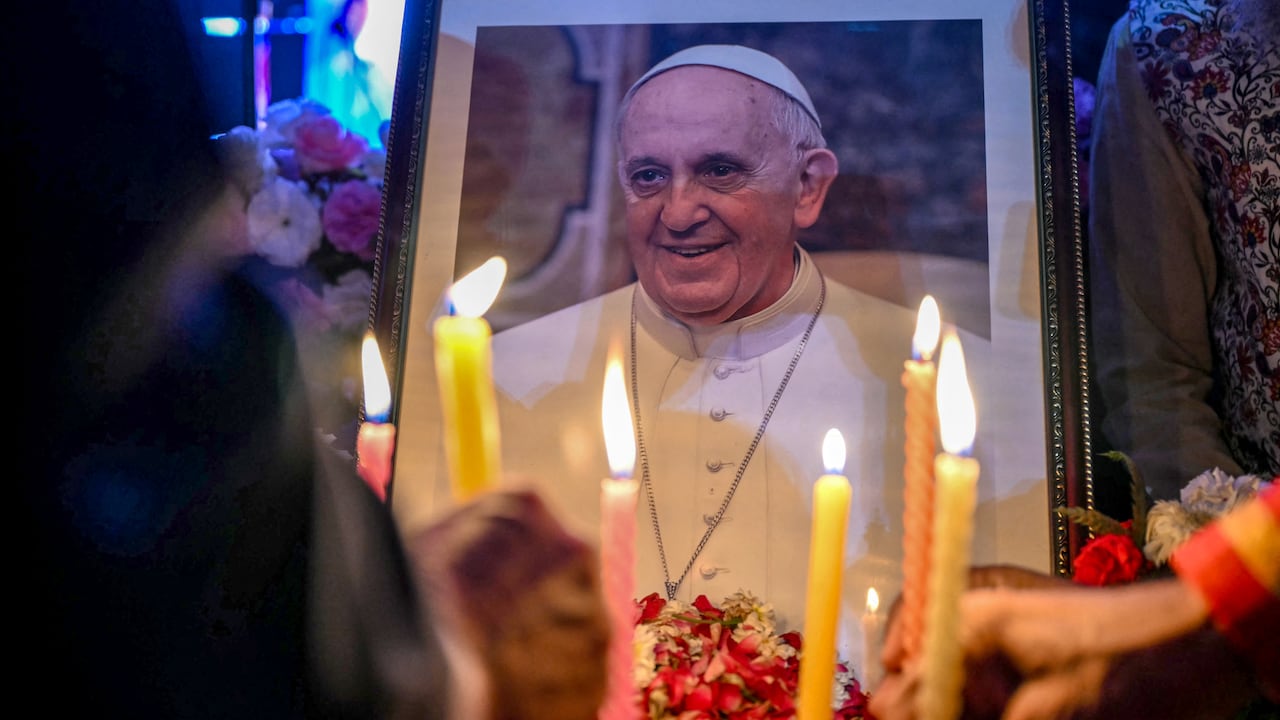Varias personas encienden velas mientras presentan sus respetos frente a un retrato del papa Francisco en Nueva Delhi, el 21 de abril de 2025, tras la noticia de su muerte. (Photo by Sajjad HUSSAIN / AFP)