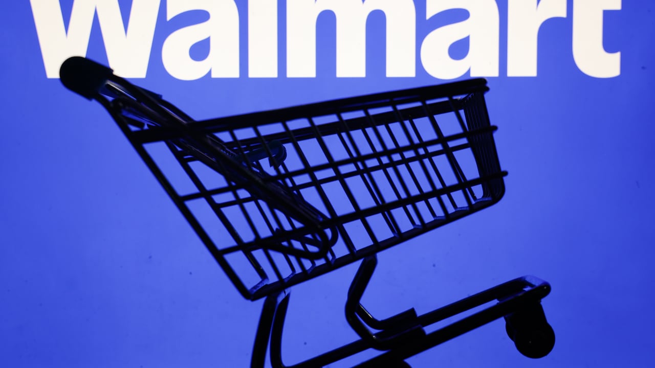 En esta ilustración, tomada en Cracovia, Polonia, el 3 de junio de 2025, se ve el logotipo de Walmart en una pantalla y un pequeño carrito de compras