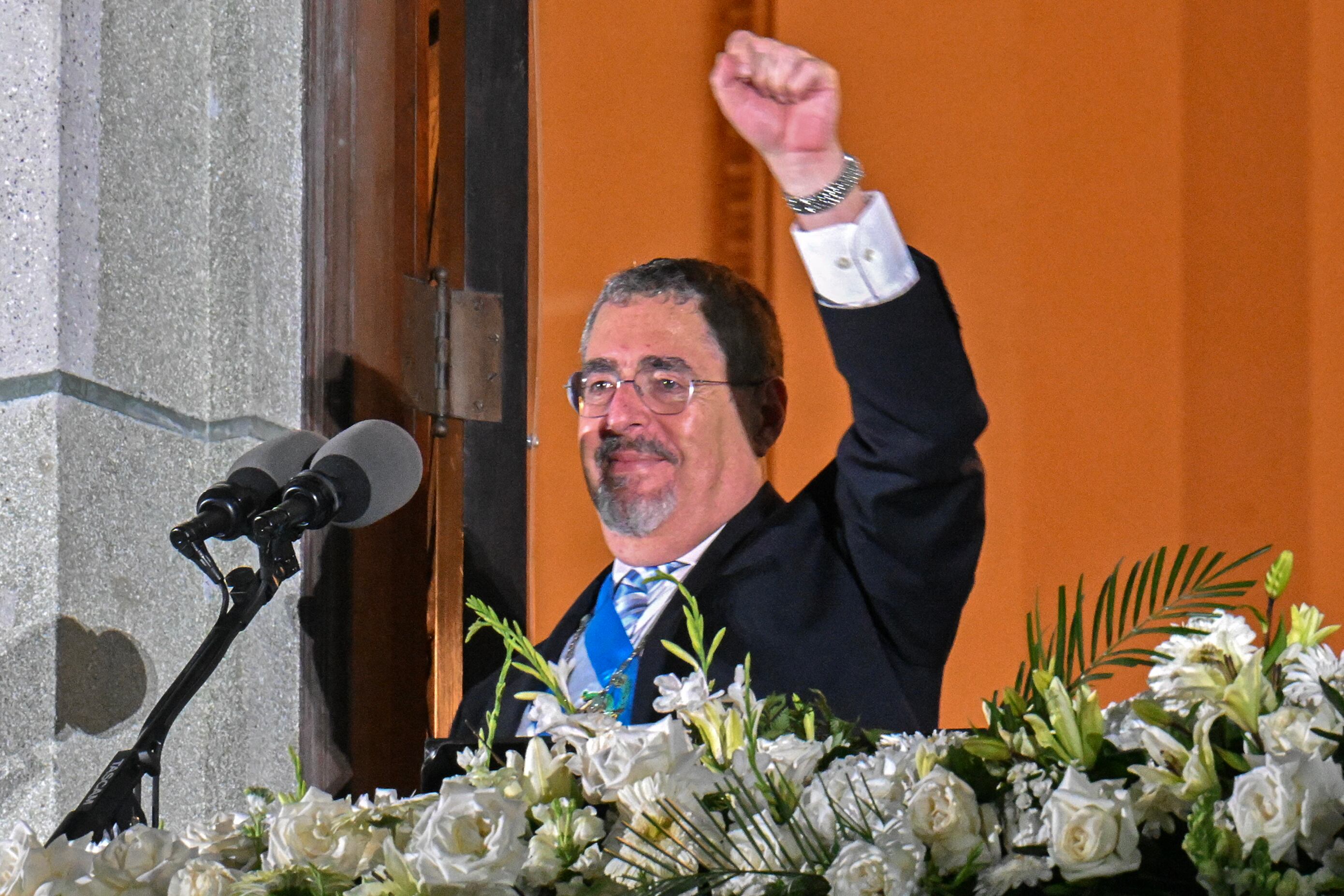 Guatemala's new President Bernardo Arevalo gestures at supporters from a balcony of the Culture National Palace in Guatemala City, after his inauguration ceremony, early on January 15, 2024. Bernardo Arevalo was finally sworn in as Guatemala's president on early Monday after the ceremony was delayed for more than nine hours, capping months of judicial machinations to block the anti-corruption crusader from taking office. (Photo by JOHAN ORDONEZ / AFP)