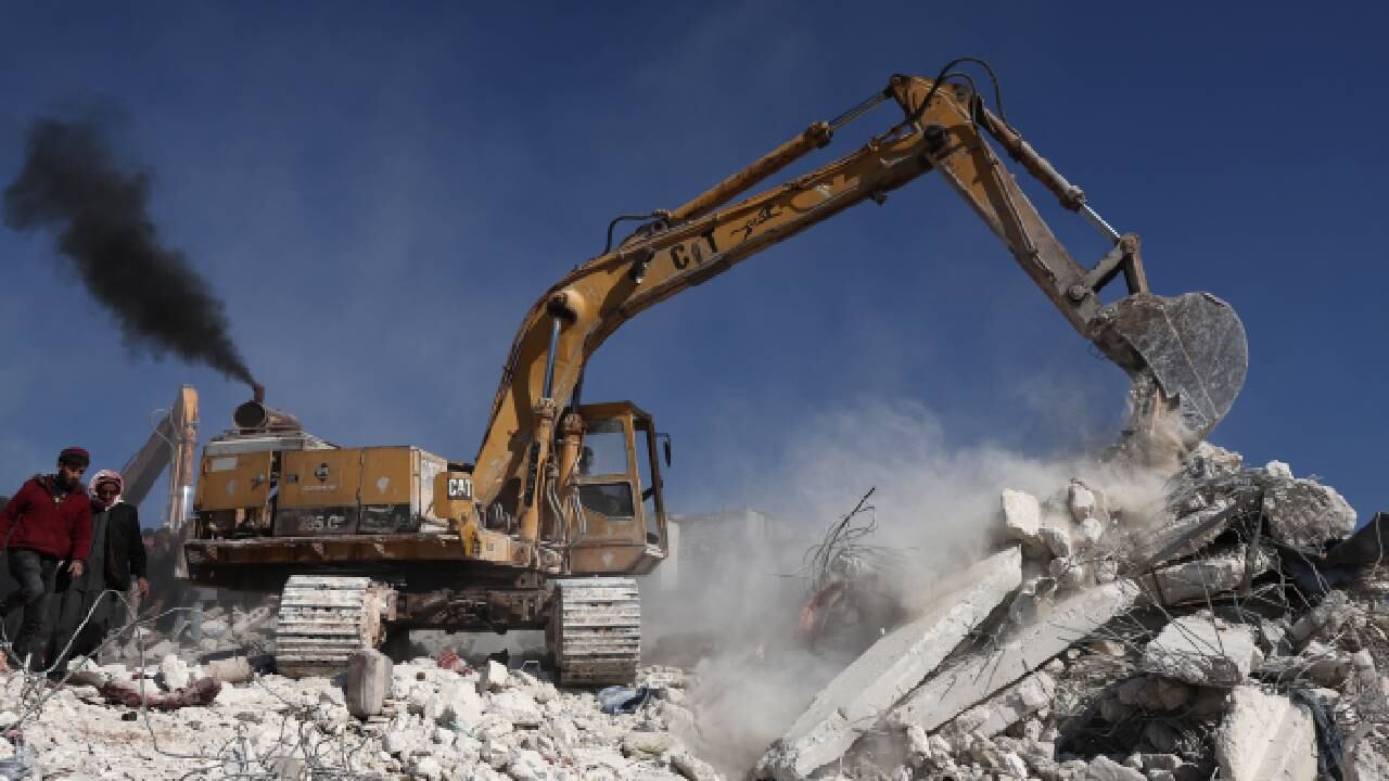 Rescatistas y residentes de los Cascos Blancos sirios buscan sobrevivientes entre los escombros de un edificio derrumbado en la provincia siria de Idlib.