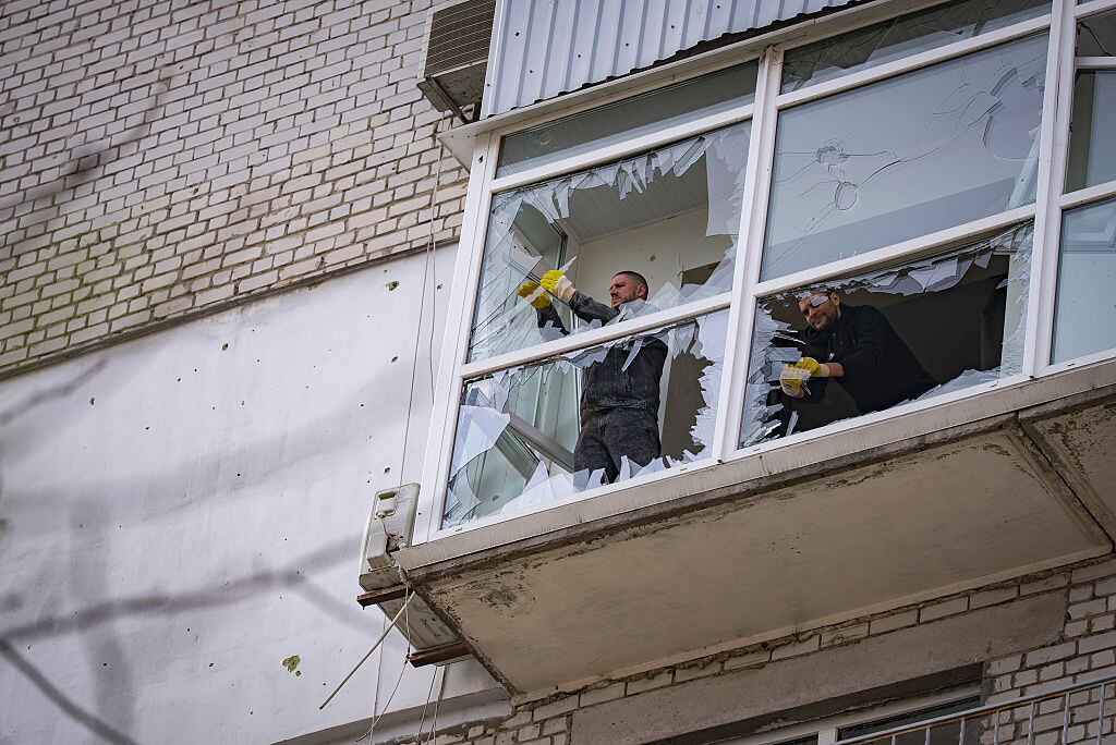 DNIPRO, UKRAINE - MARCH 27: Men remove shattered glass on a balcony in a residential building damaged by Russian drone attack on March 27, 2025 in Dnipro, Ukraine. In Dnipro, three people were injured in a massive Russian drone attack on the evening of March 26. The shelling damaged businesses, educational and cultural institutions, and more than a dozen high-rise residential buildings. More than 60 cars were damaged, and several more were destroyed. On the morning of March 27, residents, workers of damaged buildings, and municipal services came out to overcome the consequences of the strikes. They remove debris, glass, and shattered furniture. Tow trucks remove fire-damaged cars. (Photo by Yurii Tynnyi/Suspilne Ukraine/JSC "UA:PBC"/Global Images Ukraine via Getty Images)