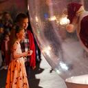 A young girl and boy visit with the Santa in the snow globe during Automobile Alley's Lights on Broadway in Oklahoma City, Okla., Saturday, Dec. 5, 2020. The snow globe was used as a way to keep social distancing for COVID-19, but still, let children see Santa. (Doug Hoke/The Oklahoman via AP)