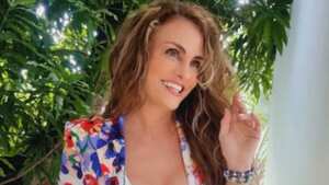 La actriz y ahora modelo de Only Fans, Aura Cristina Geithner posa junto a los árboles con una chaqueta de flores.