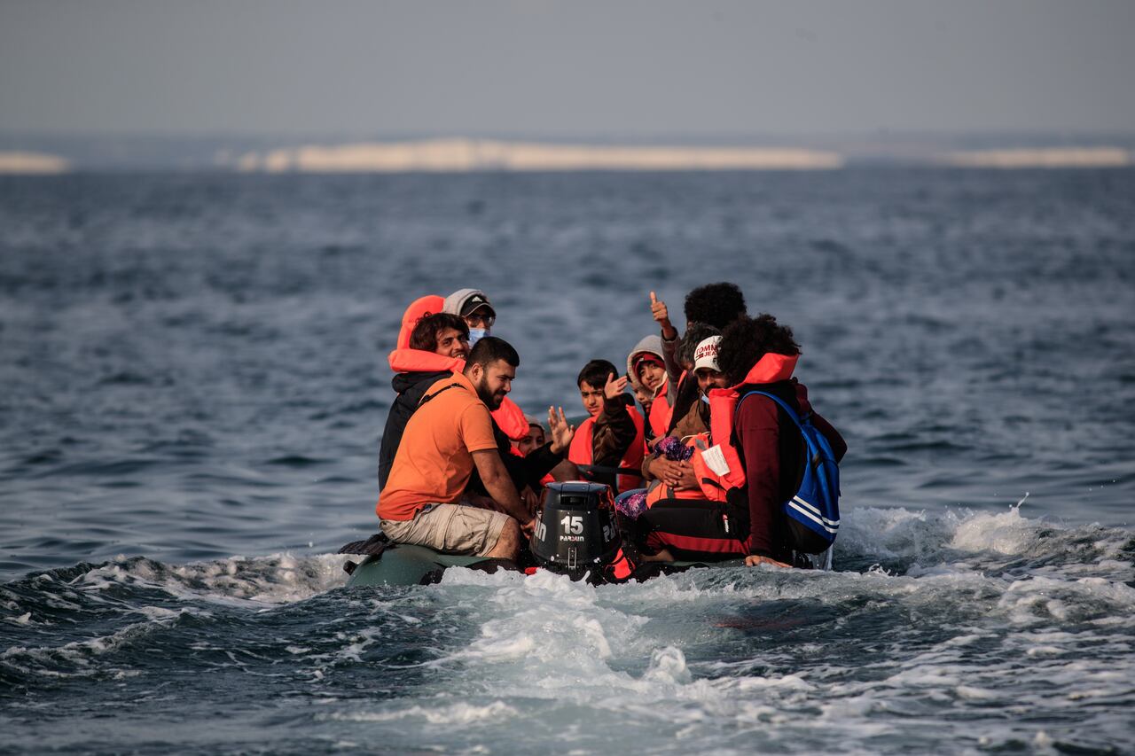 Migrants, including women and children, in a dinghy, react as they approach the southern British coastline as they illegally cross the English Channel from France on September 11, 2020. - The number of migrants crossing the English Channel -- which is 33,8 km (21 miles) at the closest point in the Straits of Dover -- in small inflatable boats has spiralled over the summer of the 2020. According to authorities in northern France some 6,200 migrants have attempted the crossing between January 1 and August 31, 2020, compared with 2,294 migrants for the whole of 2019. (Photo by Sameer Al-DOUMY / AFP)