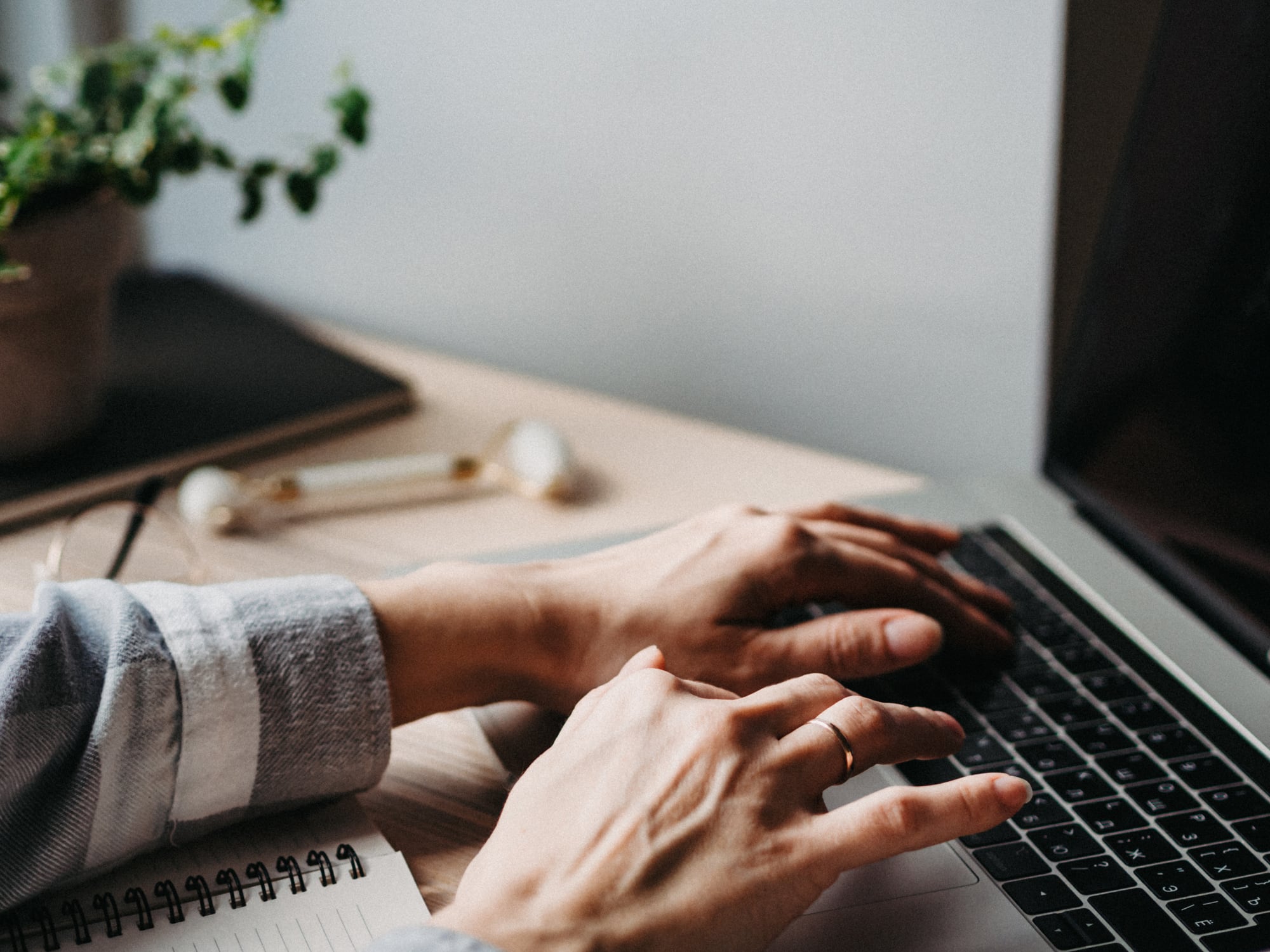 Woman working at home office hand on keyboard. Home workspace - wooden table laptop. Beautiful workspace - online remote work from home concept. close up