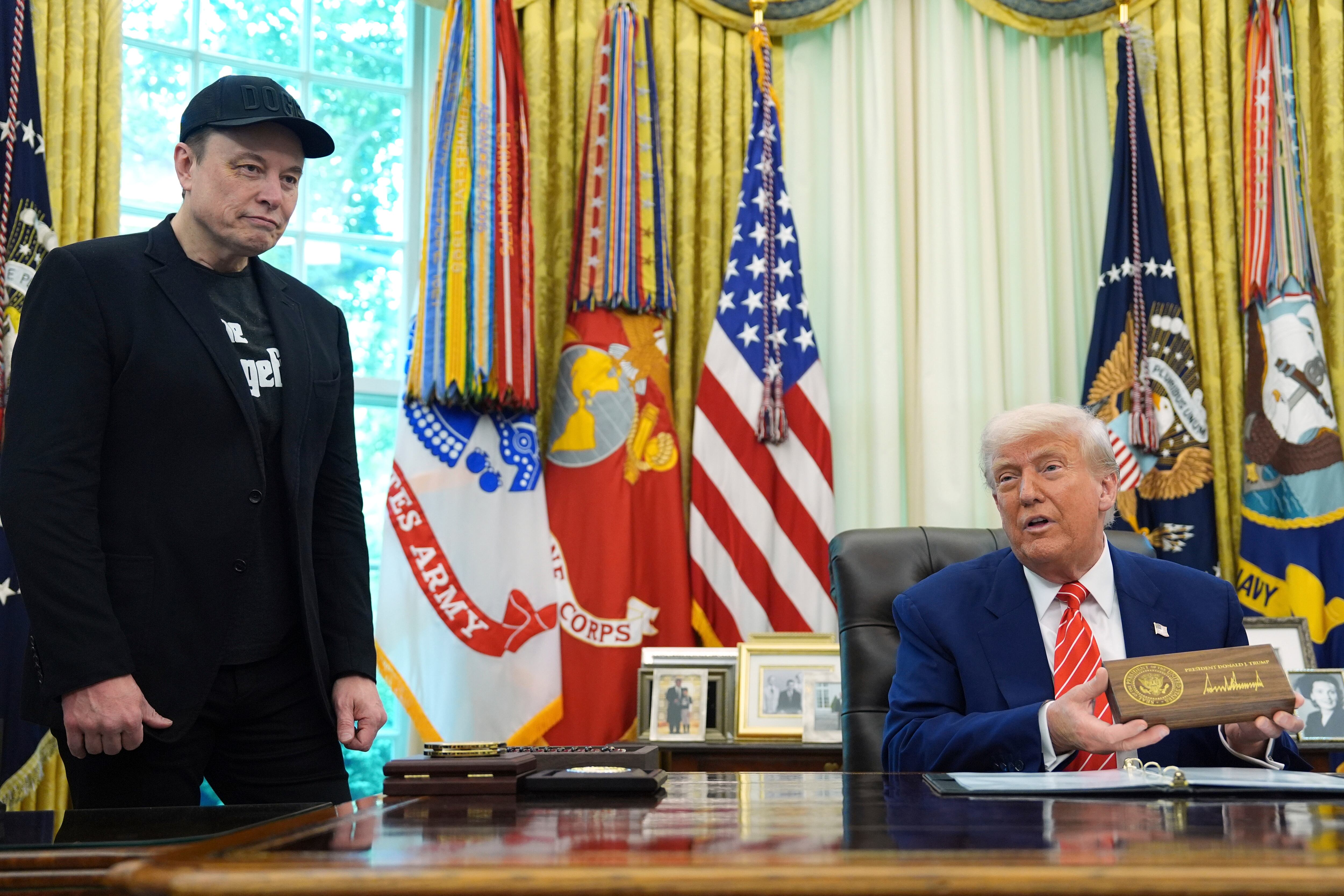 President Donald Trump speaks as he holds a box containing a key before presenting it to Elon Musk, left, during a news conference in the Oval Office of the White House, Friday, May 30, 2025, in Washington. (AP Photo/Evan Vucci)