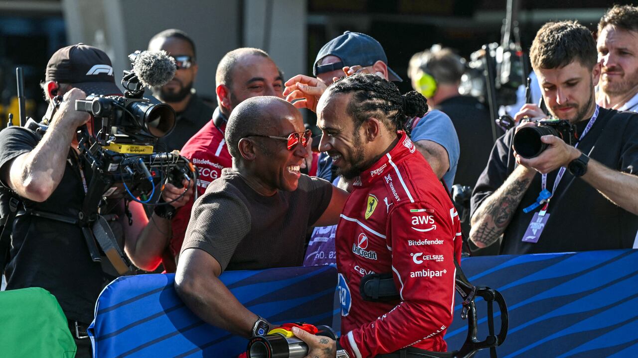 Ferrari's British driver Lewis Hamilton (centre R) celebrates taking pole position with his father Anthony Hamilton (centre L) after the sprint qualifying session of the Formula One Chinese Grand Prix at the Shanghai International Circuit in Shanghai on March 21, 2025. (Photo by GREG BAKER / AFP)