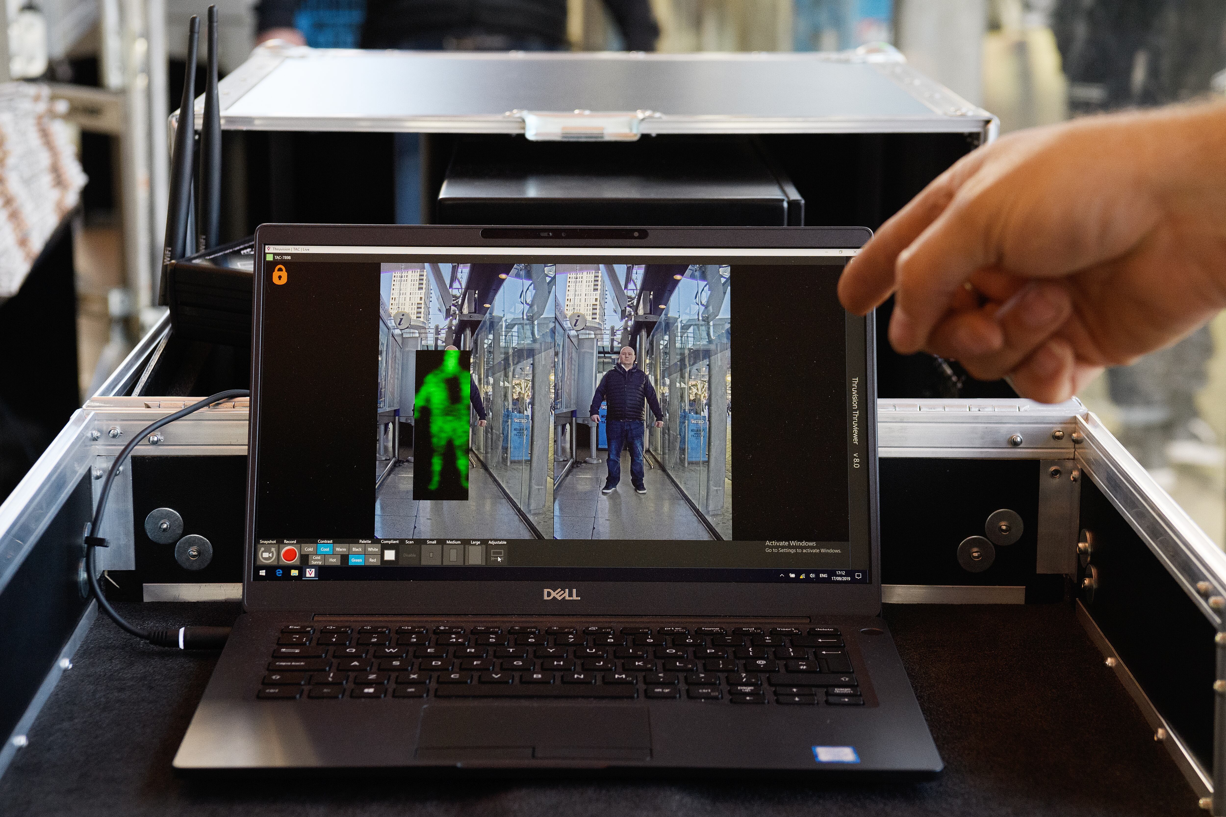 Un miembro del equipo Thruvision aparece en la pantalla posando durante una manifestación mientras la Policía de Transporte Británica supervisa una prueba operativa del sistema de cámaras Thruvision en la estación de Stratford, el 17 de septiembre de 2019 en Stratford,