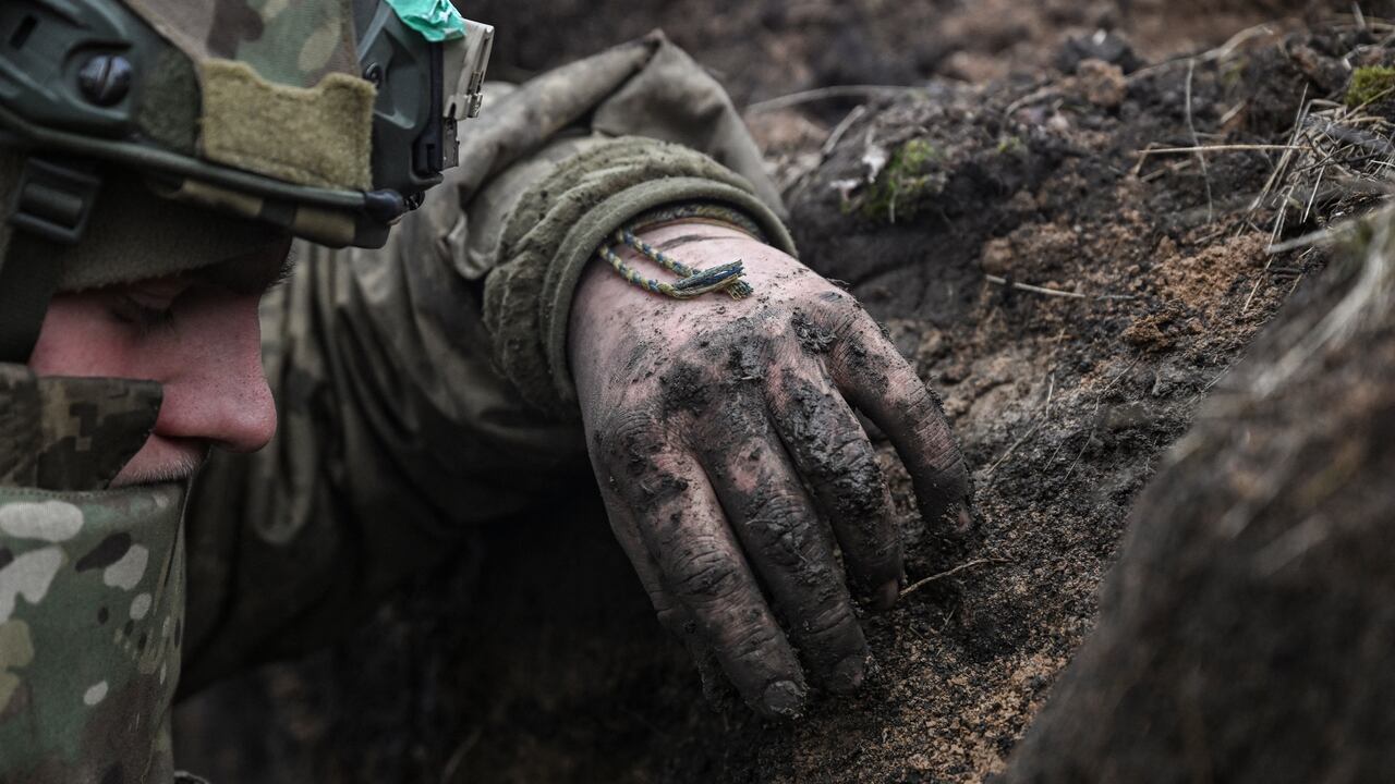 Un militar ucraniano se refugia en una trinchera durante un bombardeo, cerca de la ciudad de Bakhmut, el 8 de marzo de 2023.