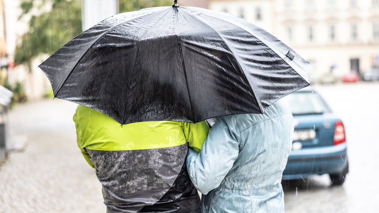 Pareja que se protege de la lluvia