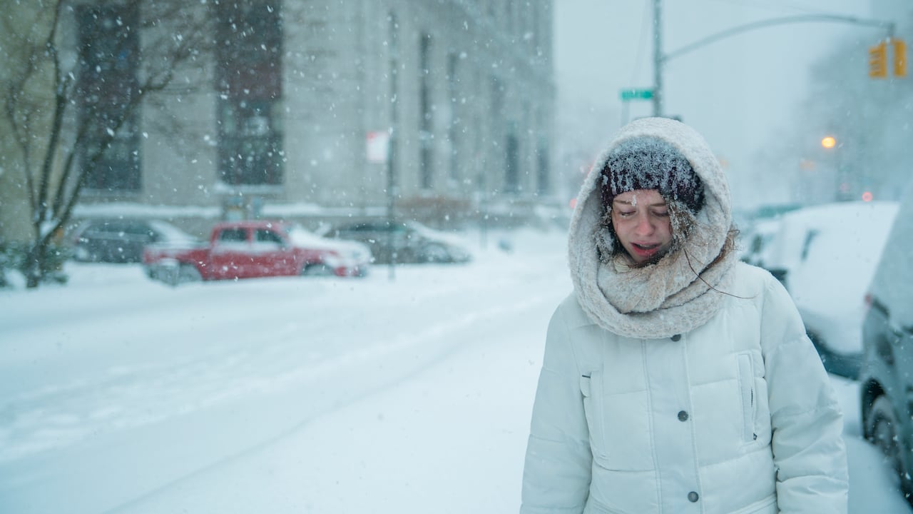 Mujer caminando en tormenta de nieve en Nueva York, Estados Unidos.