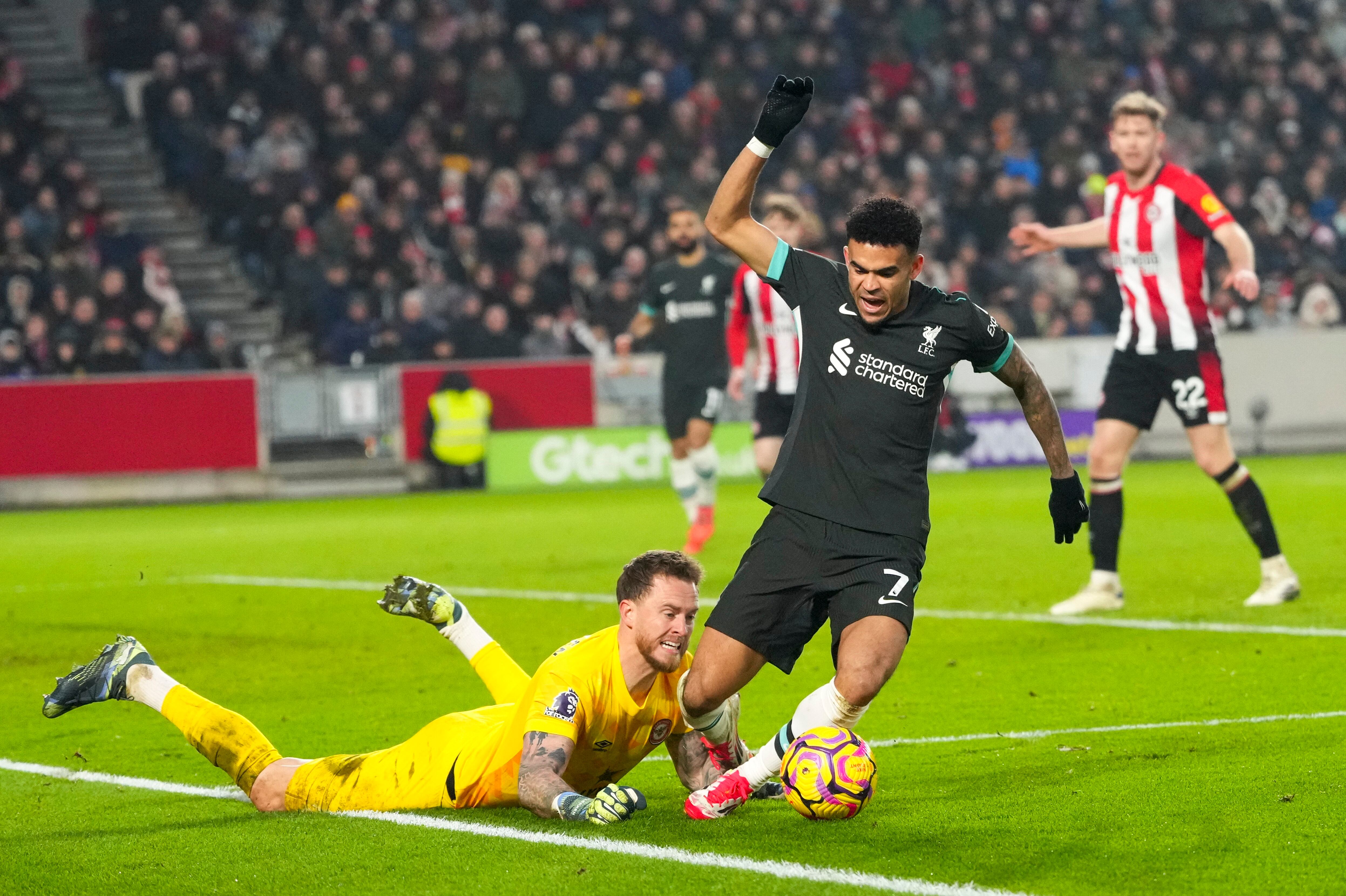 Liverpool's Luis Diaz is challenged by Brentford's goalkeeper Mark Flekken during the English Premier League soccer match between Brentford and Liverpool at the GTech Community Stadium in London, Saturday, Jan. 18, 2025. (AP Photo/Kirsty Wigglesworth)