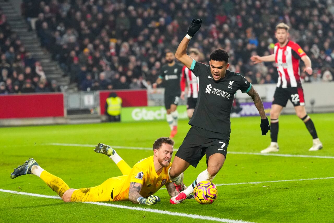 Liverpool's Luis Diaz is challenged by Brentford's goalkeeper Mark Flekken during the English Premier League soccer match between Brentford and Liverpool at the GTech Community Stadium in London, Saturday, Jan. 18, 2025. (AP Photo/Kirsty Wigglesworth)