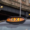 Illuminated yellow taxi sign on a typical old style black taxi in Manchester, Great Britain. Close up.