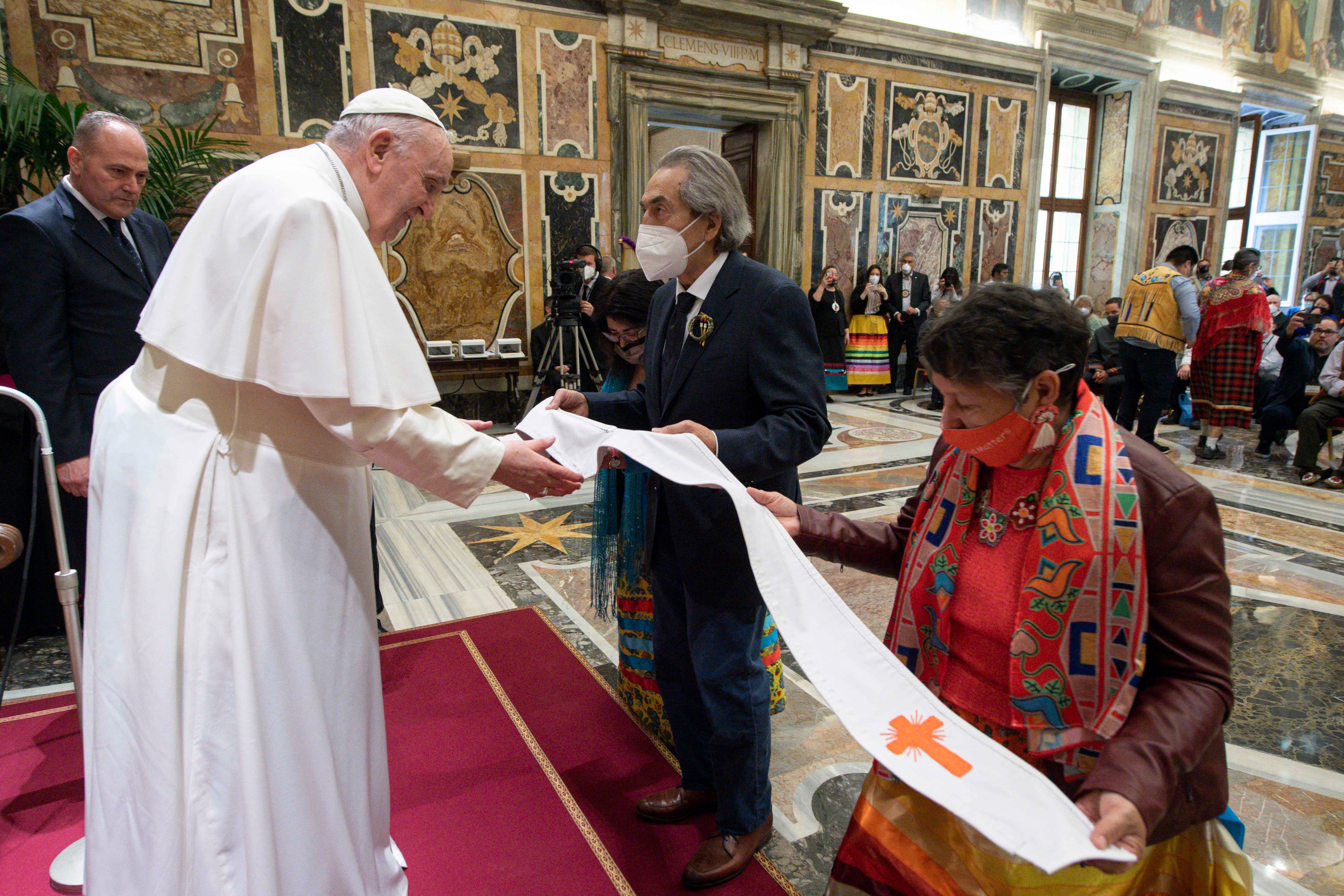 Esta foto tomada y distribuida el 1 de abril de 2022 muestra al Papa Francisco recibiendo una estola del exjefe nacional de la Asamblea de las Primeras Naciones (AFN) de Canadá (AFN), Phil Fontaine (centro), durante una audiencia con las delegaciones indígenas de Canadá en el Vaticano. - El Papa Francisco se disculpó el 1 de abril por las décadas de abuso en las escuelas residenciales administradas por la iglesia en Canadá y dijo que visitaría el país a fines de julio. (Photo by Handout / VATICAN MEDIA / AFP) / RESTRINGIDO A USO EDITORIAL - CRÉDITO OBLIGATORIO "AFP PHOTO / VATICAN MEDIA" - SIN MARKETING - SIN CAMPAÑAS PUBLICITARIAS - DISTRIBUIDO COMO SERVICIO A CLIENTES
