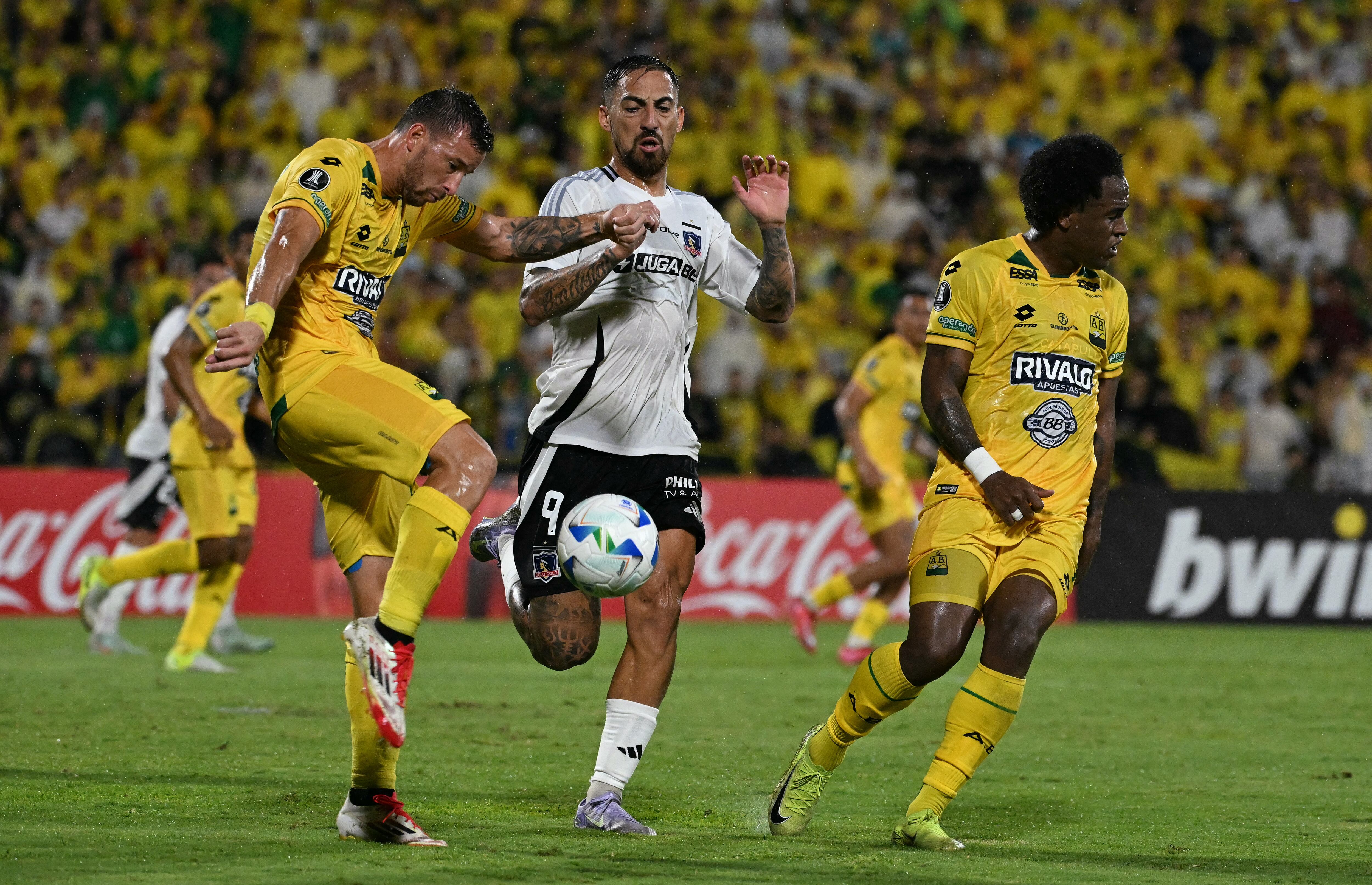 Bucaramanga's Argentine forward #27 Luciano Pons (L), midfielder #07 Kevin Londono (R) and Colo-Colo's Argentine forward #09 Javier Correa fight for the ball during the Copa Libertadores group stage first round football match between Colombia's Atletico Bucaramanga and Chile's Colo Colo at the Americo Montanini stadium in Bucaramanga, Colombia, on April 1, 2025. (Photo by Luis ACOSTA / AFP)