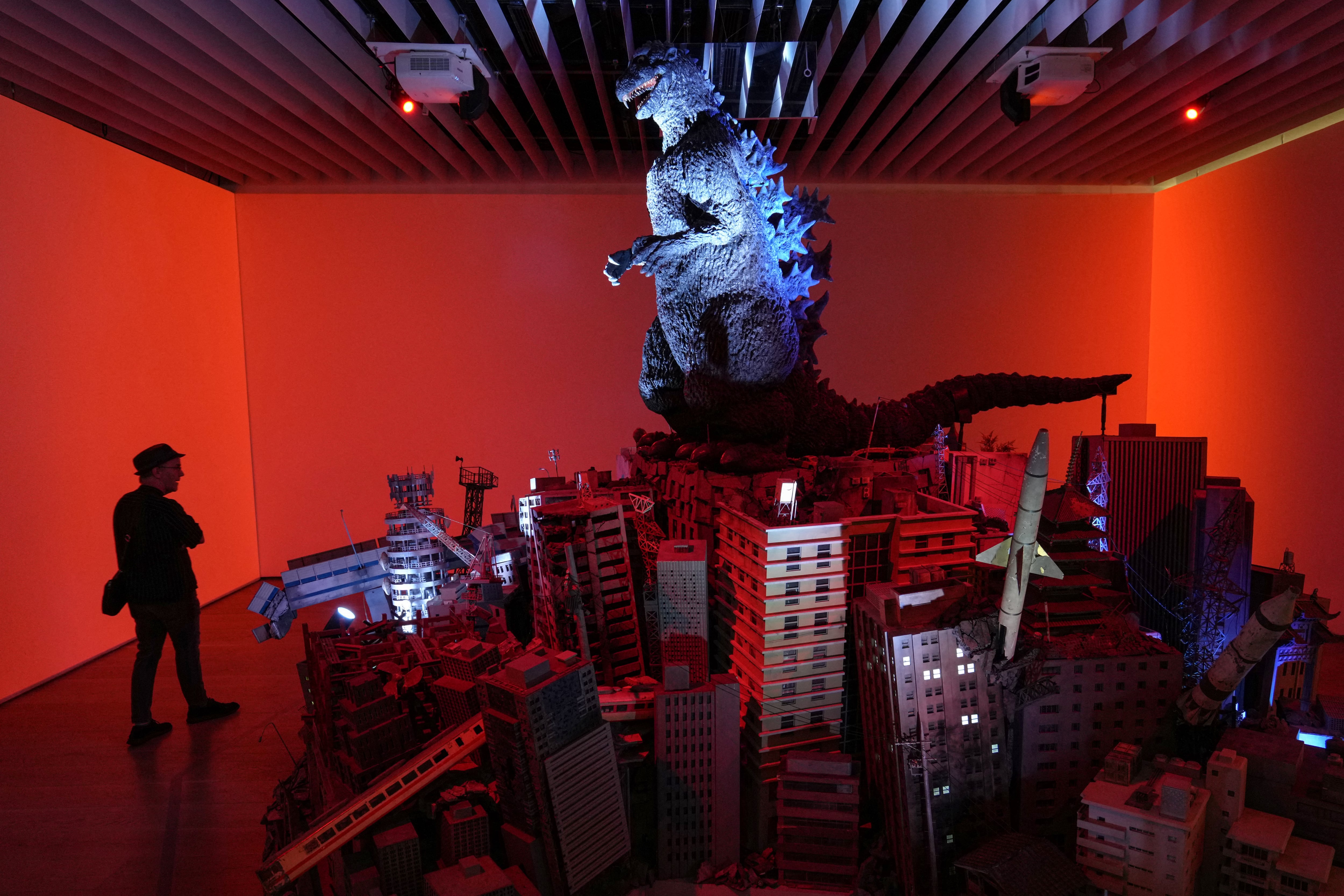 En junio de 2025, un hombre visita la exposición que conmemora el 70.º aniversario del nacimiento de Godzilla, titulada GODZILLA EL ARTE, en la Galería del Centro de Artes Mori de Tokio. Desde el ardiente aliento atómico de Godzilla hasta las desgarradoras representaciones literarias de la enfermedad por radiación, la influencia de los bombardeos nucleares de Hiroshima y Nagasaki está profundamente arraigada en la cultura popular japonesa. Foto: AFP / Kazuhiro Nogi.
