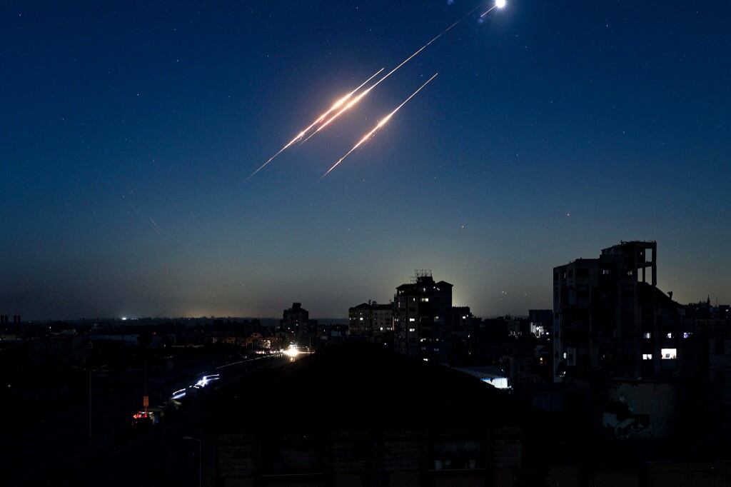 Estelas de misiles iraníes lanzados contra Israel se ven en el cielo desde el campo de refugiados de Nuseirat en la asediada Franja de Gaza el 15 de junio de 2025. Israel e Irán intercambiaron intensos disparos por tercer día consecutivo el 15 de junio, con crecientes bajas y objetivos en expansión, lo que marca una aguda escalada de hostilidades entre los viejos enemigos. (Photo by Eyad BABA / AFP)