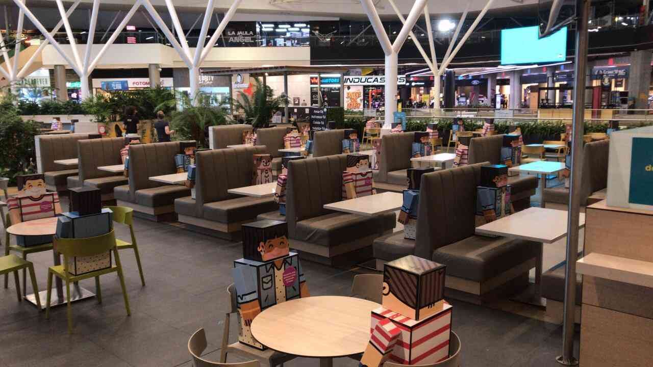 Estos muñecos sentados en las mesas son señales de cómo se debe ubicar la gente en los restaurantes para guardar el distanciamiento.