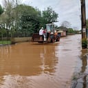 Una familia cruza una calle inundada en un cargador en la ciudad de Novo Hamburgo, estado de Rio Grande do Sul, luego de que un ciclón extratropical azotara la región sur de Brasil, provocando tormentas eléctricas y vendavales, el 17 de junio de 2023.