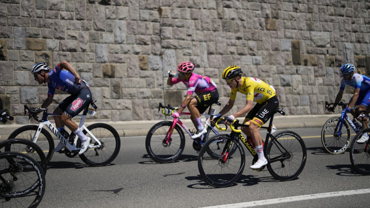 Switzerland's Silvan Dillier, Switzerland's Stefan Bissegger, and Slovenia's Tadej Pogacar, wearing the overall leader's yellow jersey, from left, ride during the ninth stage of the Tour de France cycling race over 193 kilometers (119.9 miles) with start in Aigle, Switzerland and finish in Chatel les Portes du Soleil, France, Sunday, July 10, 2022. (AP Photo/Thibault Camus)