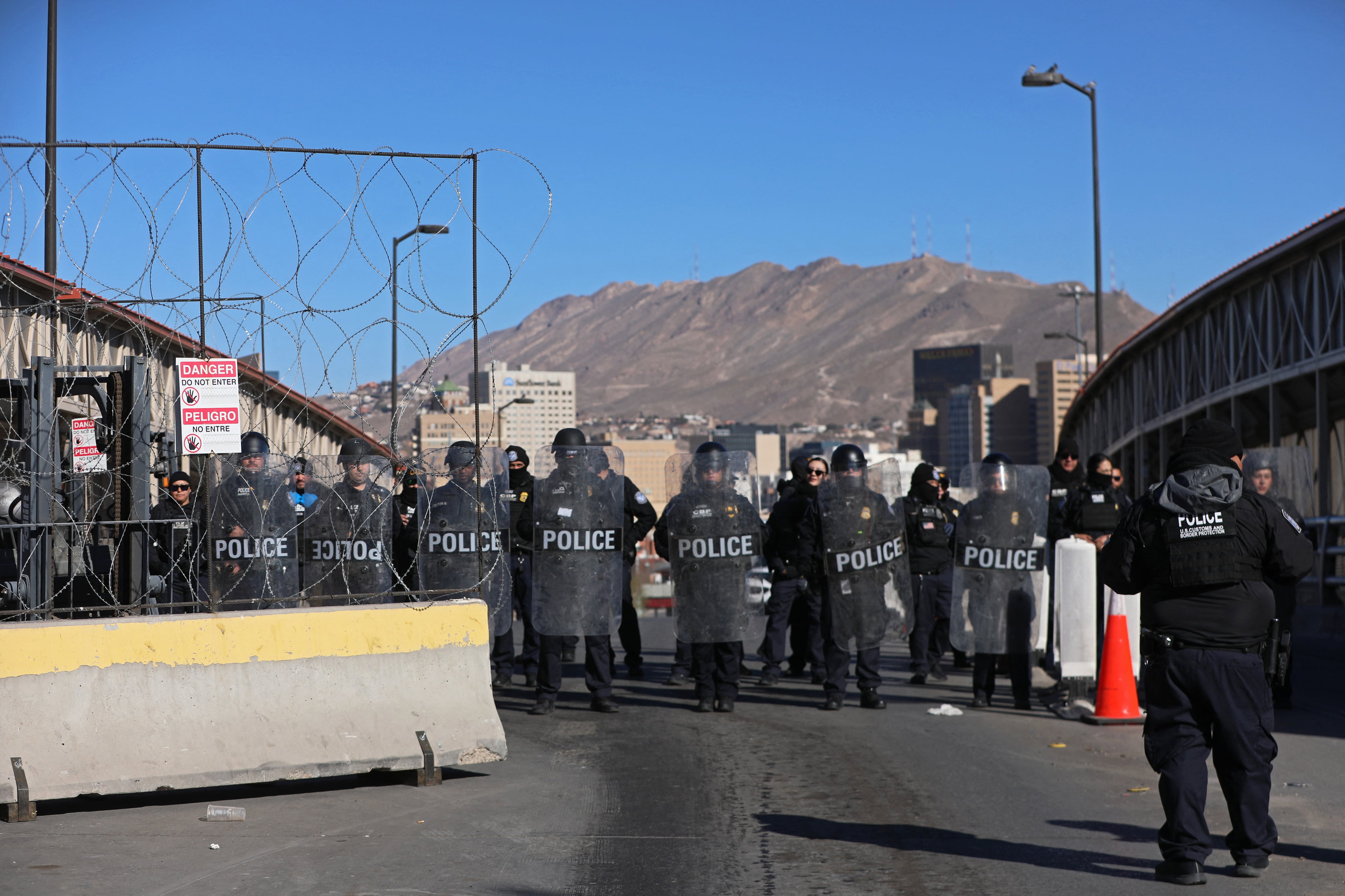 Oficiales de Aduanas y Protección Fronteriza de los Estados Unidos realizando un ejercicio de entrenamiento de fuerza de campo móvil en el puente internacional Paso del Norte-Santa Fe para bloquear el paso de vehículos a El Paso, Texas, Estados Unidos, en la foto de Ciudad Juárez, estado de Chihuahua, México, el 23 de enero de 2025.