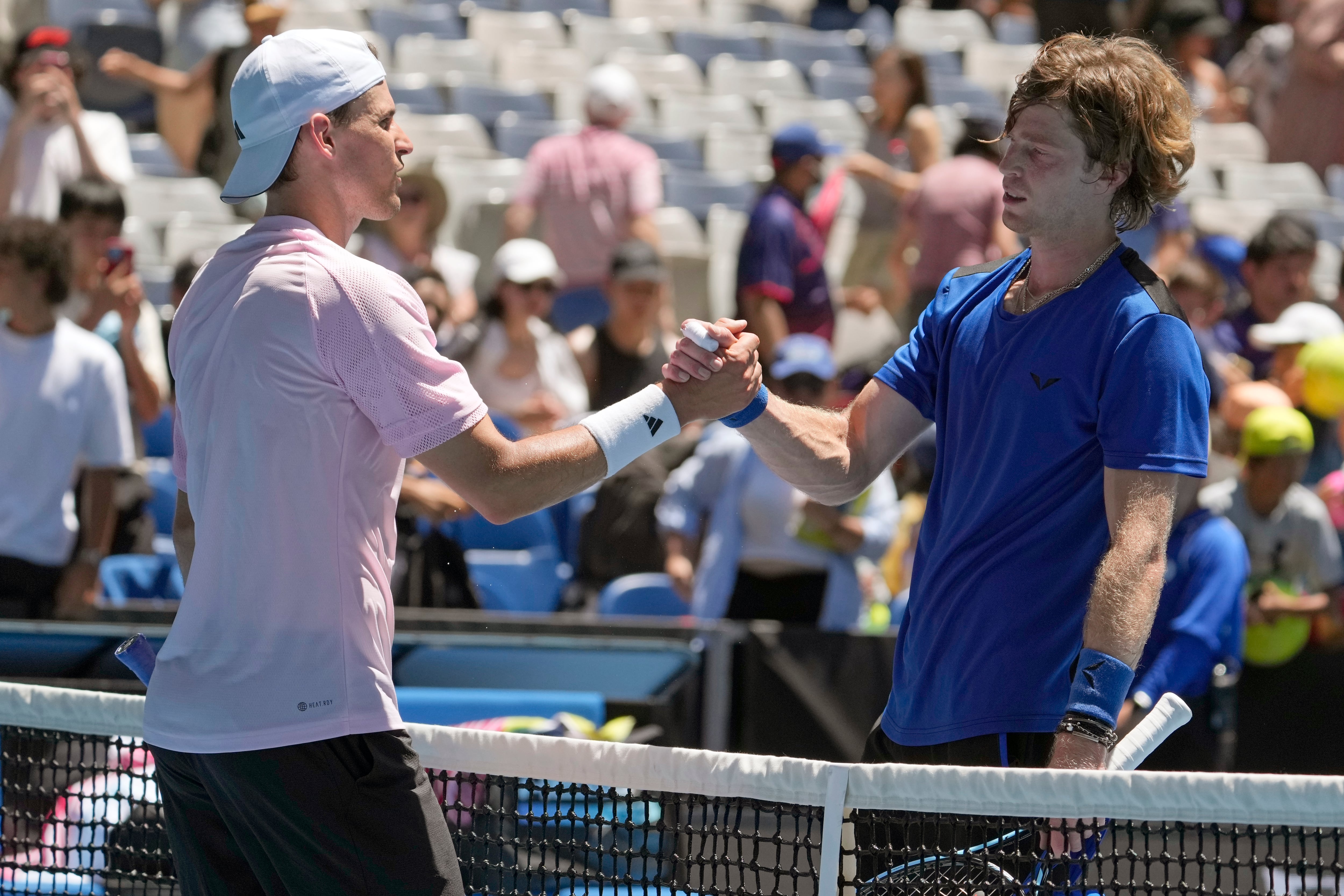 Andrey Rublev, right, of Russia is congratulated by Dominic Thiem of Austria following their first round match at the Australian Open tennis championship in Melbourne, Australia, Tuesday, Jan.17, 2023. (AP Photo/Ng Han Guan)