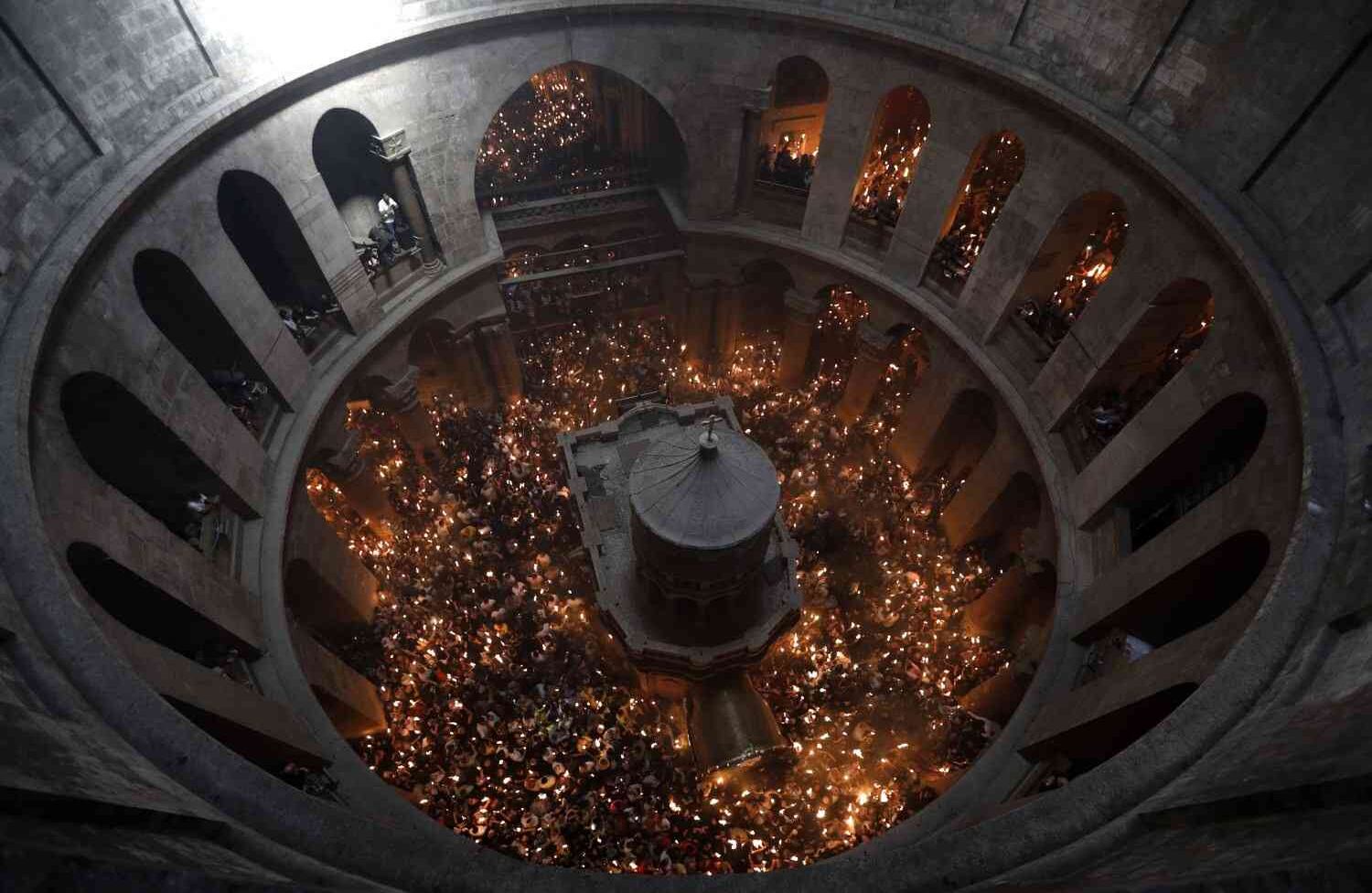Los fieles ortodoxos cristianos levantan velas durante la ceremonia del "Fuego Sagrado" cuando se reúnen en el Santo Sepulcro en la Ciudad Vieja de Jerusalén, el 7 de abril de 2018, durante las ceremonias de Pascua ortodoxa. La ceremonia se celebró de la misma manera durante once siglos. / AFP PHOTO / MENAHEM KAHANA