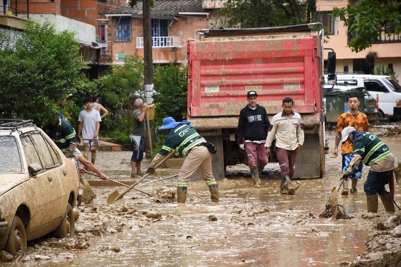 Personal de la Defensa Civil y la Cruz Roja Colombiana que se encuentran en el sitio colaboran con las labores de remoción del lodo y el agua que anegó las viviendas y las calles.