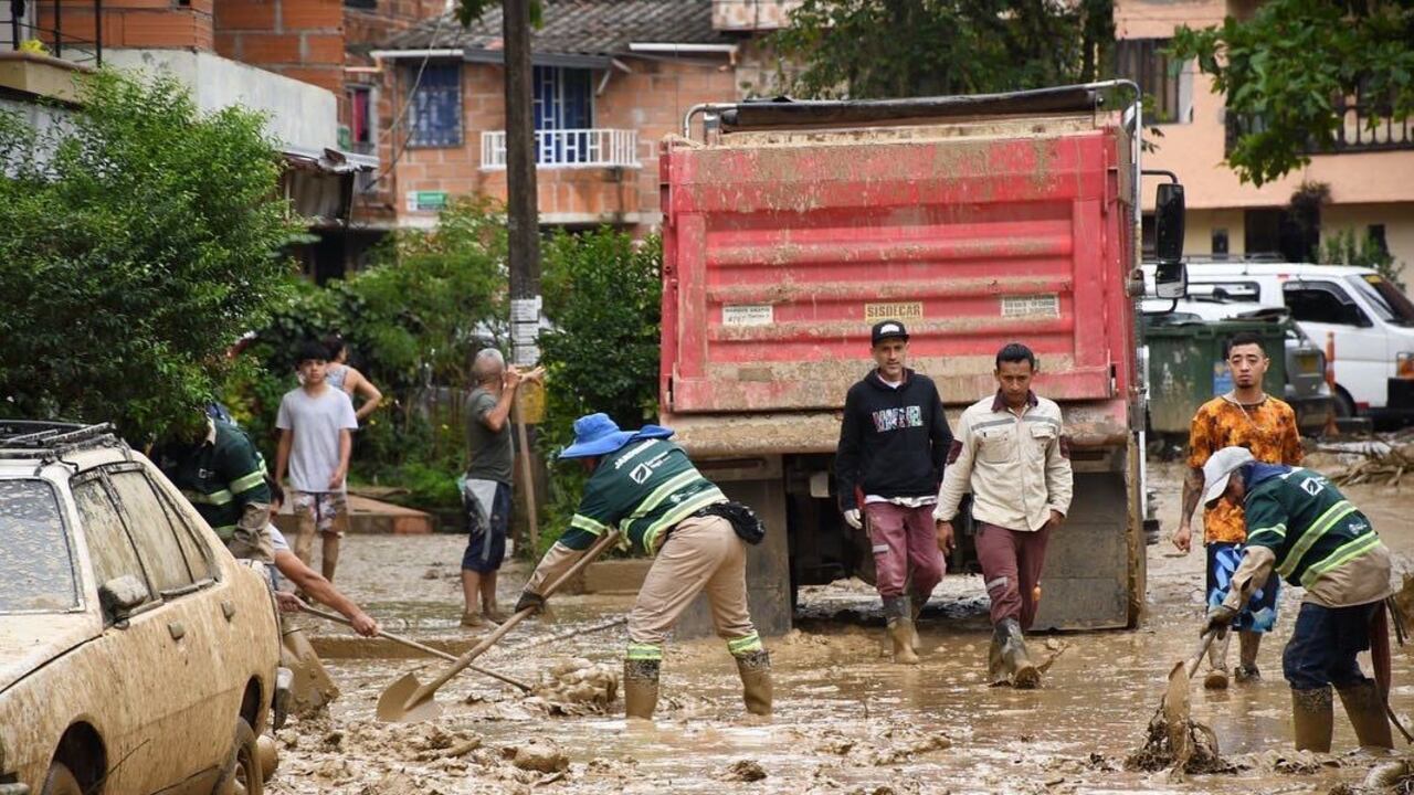 Personal de la Defensa Civil y la Cruz Roja Colombiana que se encuentran en el sitio colaboran con las labores de remoción del lodo y el agua que anegó las viviendas y las calles.