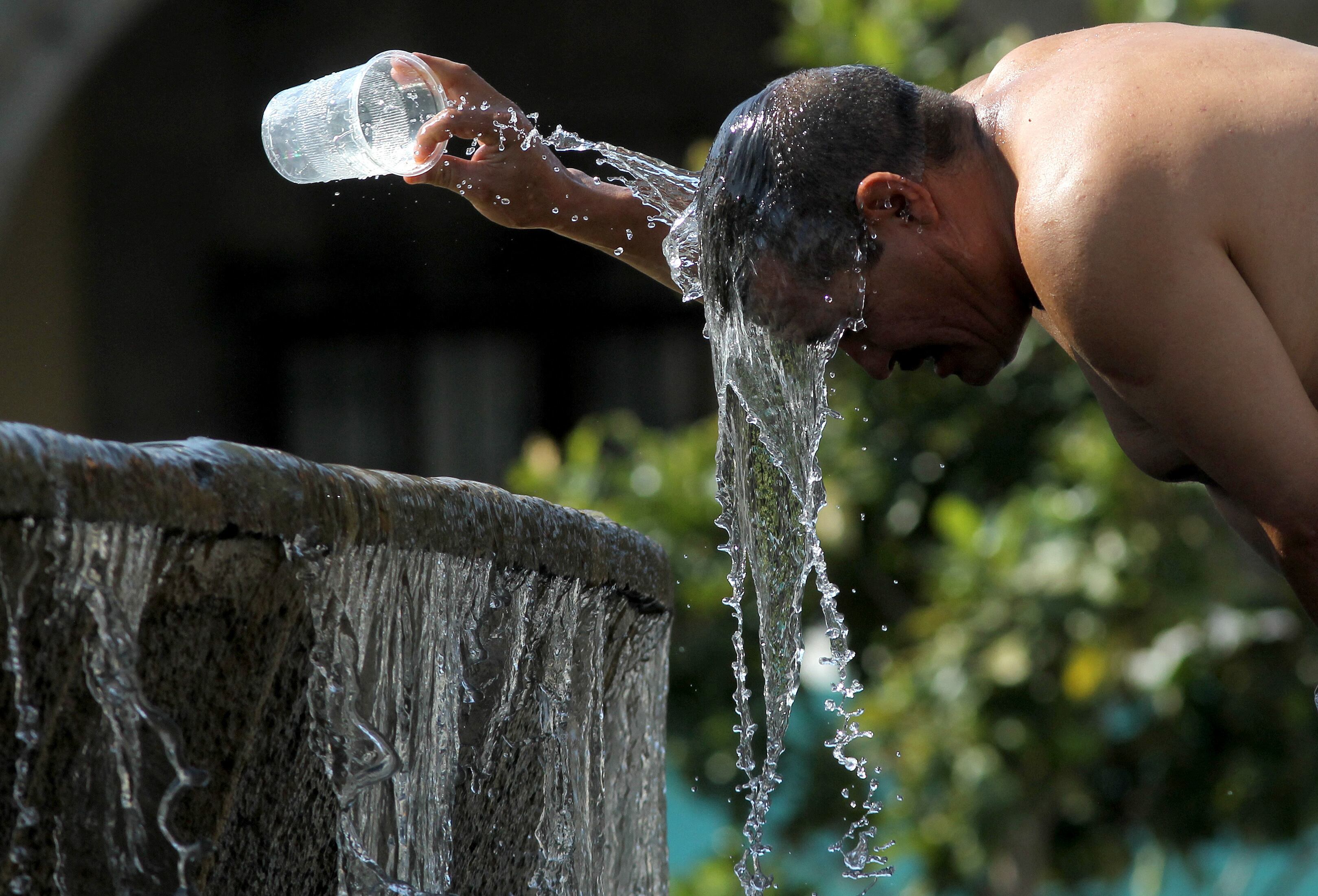 A man cools himself down with water from a water fountain during one of the hottest days of the third heat wave in Guadalajara, Jalisco state, Mexico, on June 12, 2023. (Photo by ULISES RUIZ / AFP)