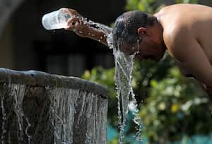 Un hombre se refresca con agua de una fuente de agua durante uno de los días más calurosos de la tercera ola de calor en Guadalajara, estado de Jalisco, México.