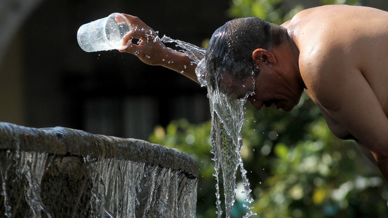 Un hombre se refresca con agua de una fuente de agua durante uno de los días más calurosos de la tercera ola de calor en Guadalajara, estado de Jalisco, México.