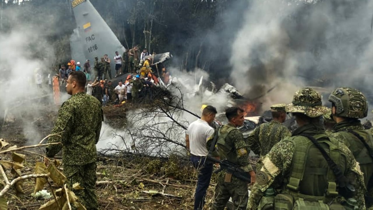 Soldados y rescatistas cerca de un Hércules de la Fuerza Aérea que emite humo espeso después de que el avión se estrellara durante el despegue en Puerto Leguizamo (Putumayo), el 23 de marzo de 2026.