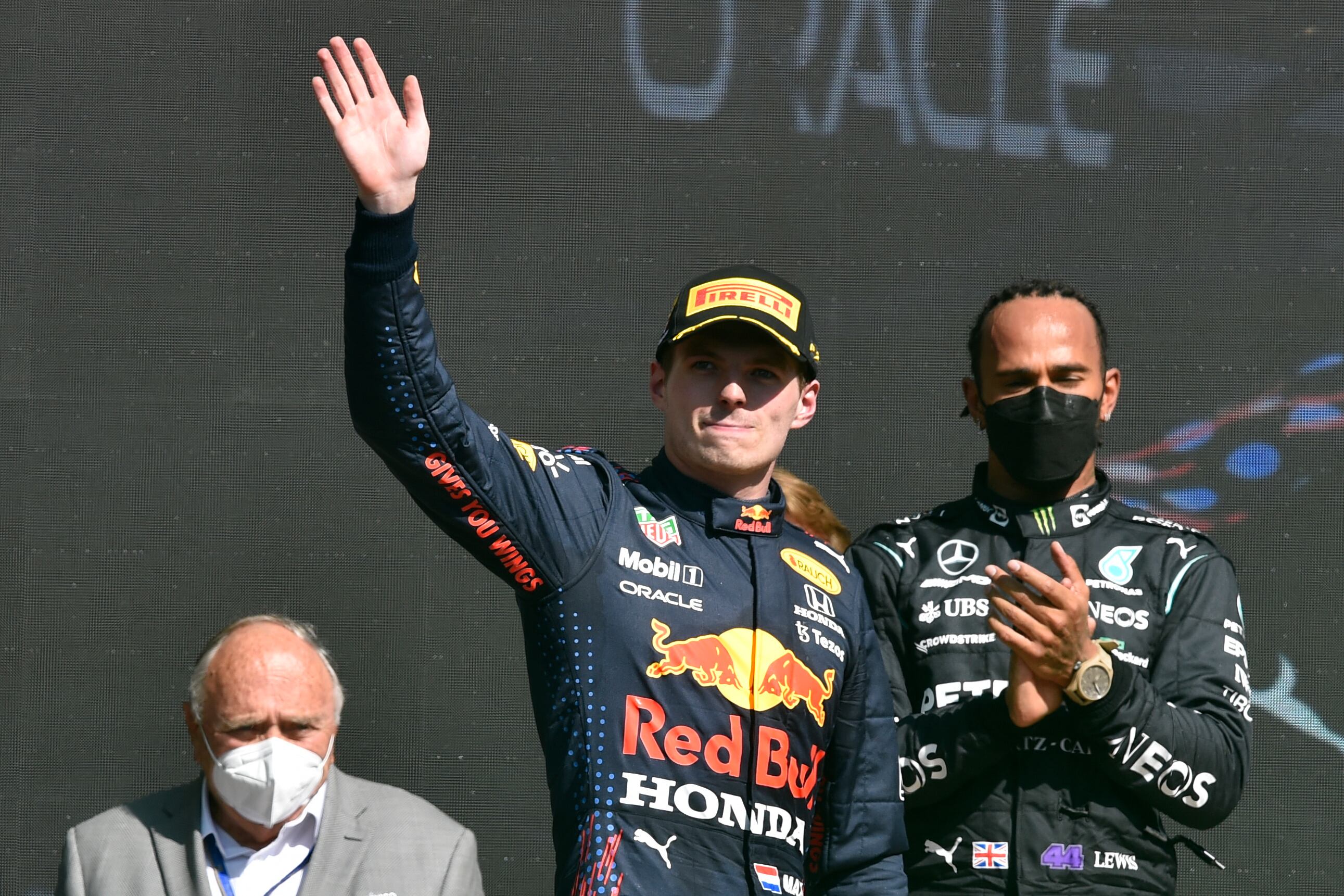 Red Bull's Dutch driver Max Verstapen (C) celebrates on the podium after winning the Formula One Mexico Grand Prix next to runner-up Mercedes' British driver Lewis Hamilton (R) at the Hermanos Rodriguez racetrack in Mexico City on City on November 7, 2021. (Photo by ALFREDO ESTRELLA / AFP)