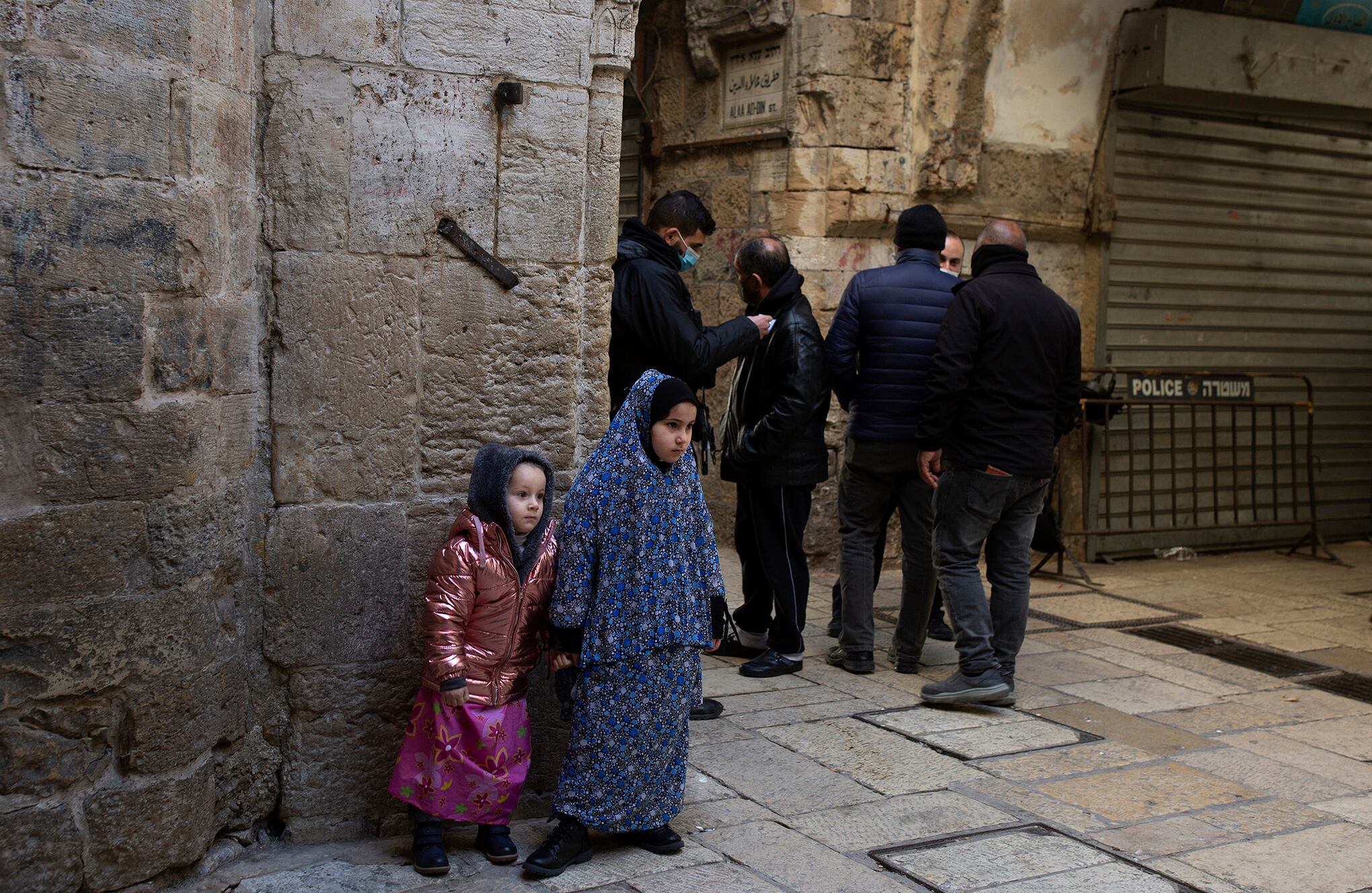 Una niña vestida con una prenda islámica de la cabeza a los pies junto a su hermana en un puesto de control policial mientras los fieles ingresan al recinto de la Mezquita Al Aqsa para las oraciones del viernes en la Ciudad Vieja de Jerusalén, el viernes 22 de enero de 2021. Muchas personas oraron afuera del puertas de la Ciudad Vieja, debido a restricciones de coronavirus. (Foto AP / Maya Alleruzzo)
